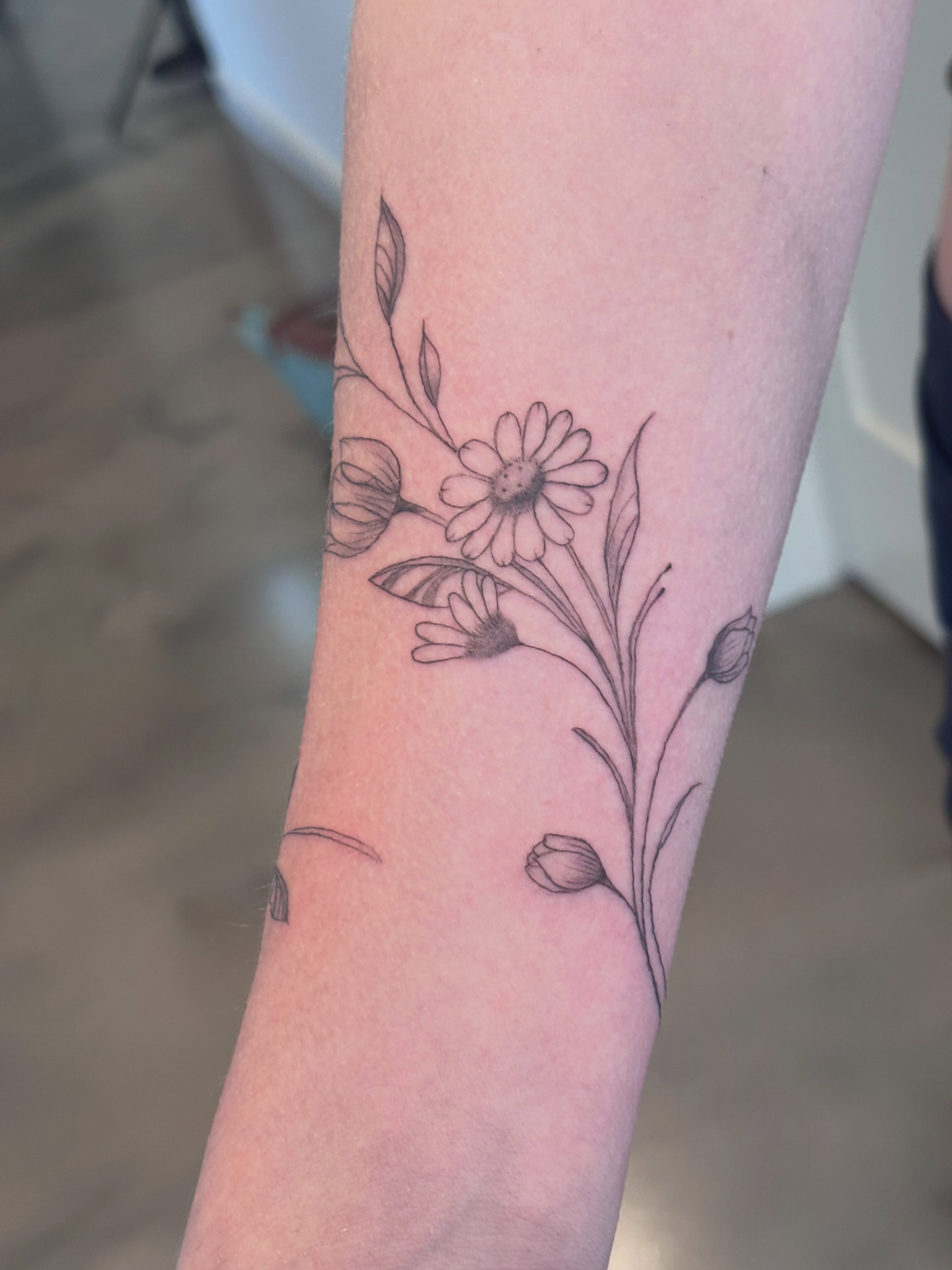 Floral arrangement black and grey tattoo on the forearm by Malissa