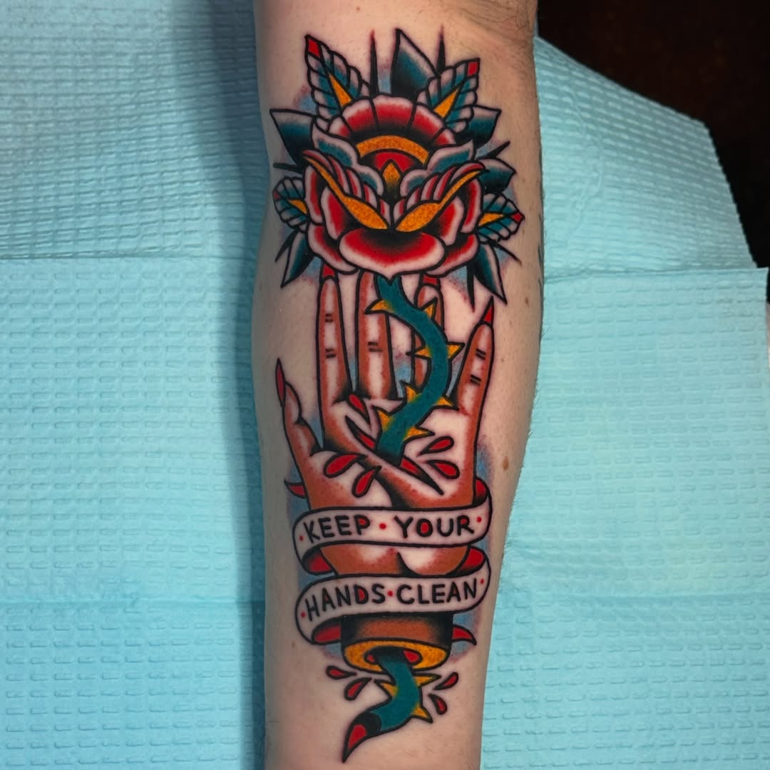 Rose and hand American traditional tattoo on the forearm by Kiki Painmaker Trad Tattooer 🧨