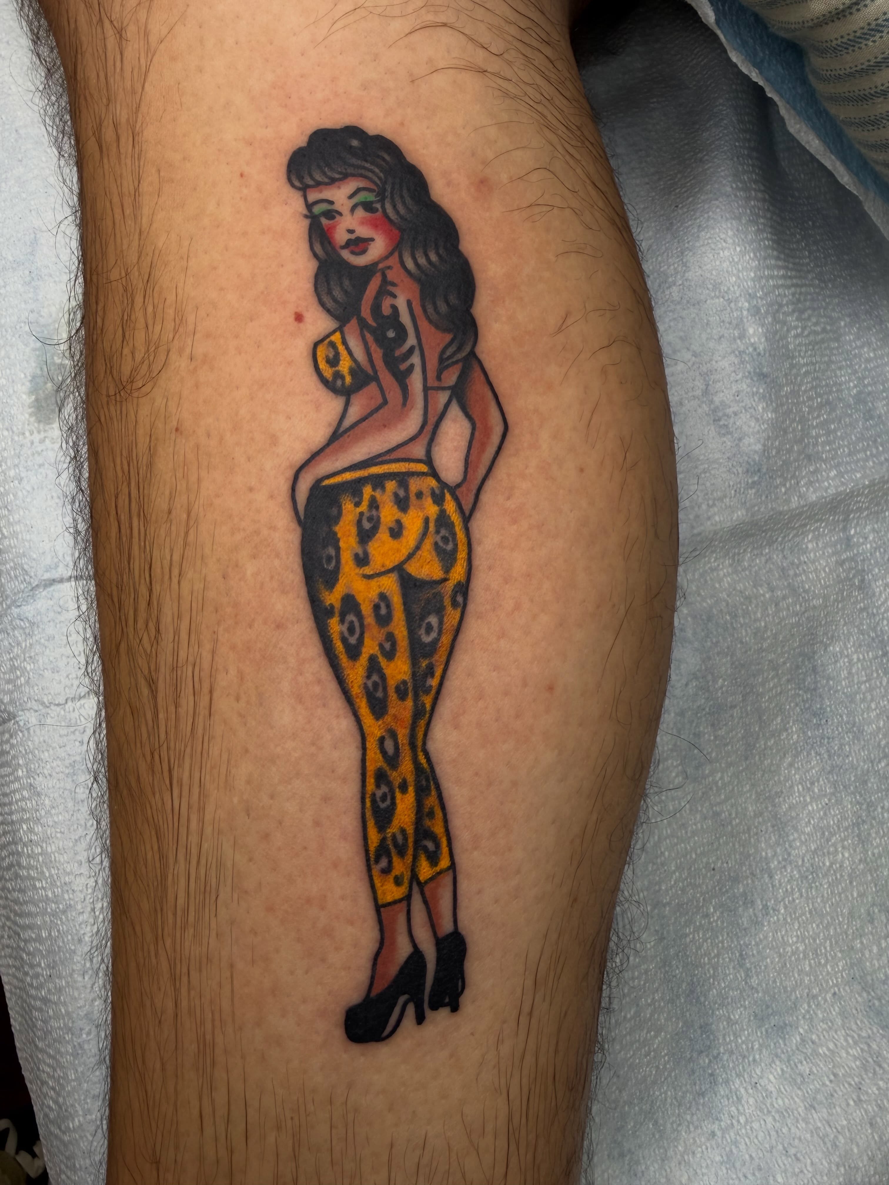 Woman in leopard print pants American traditional tattoo on the thigh by Thomas Cook
