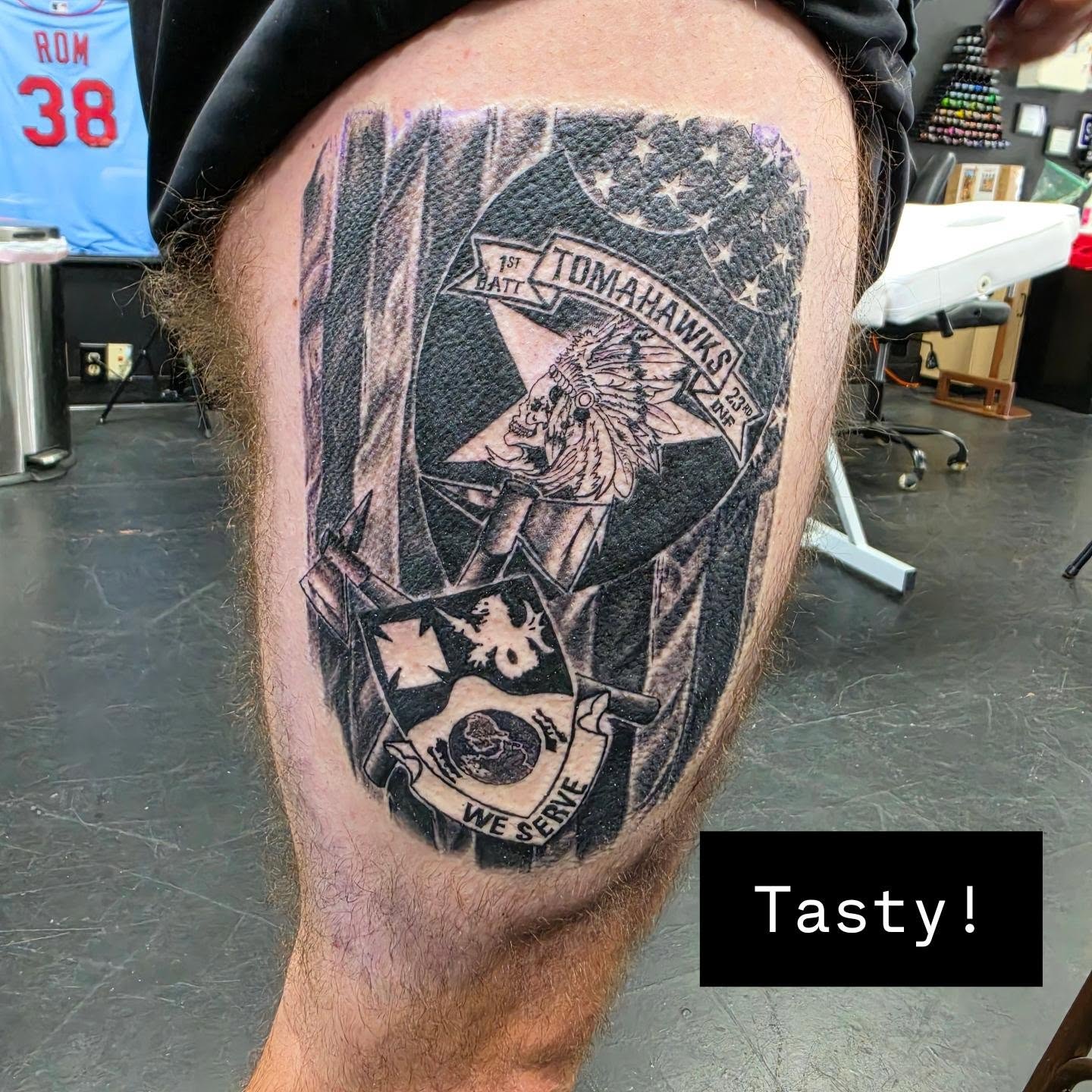 Tomahawks insignia American traditional tattoo on the thigh by Robert Glover