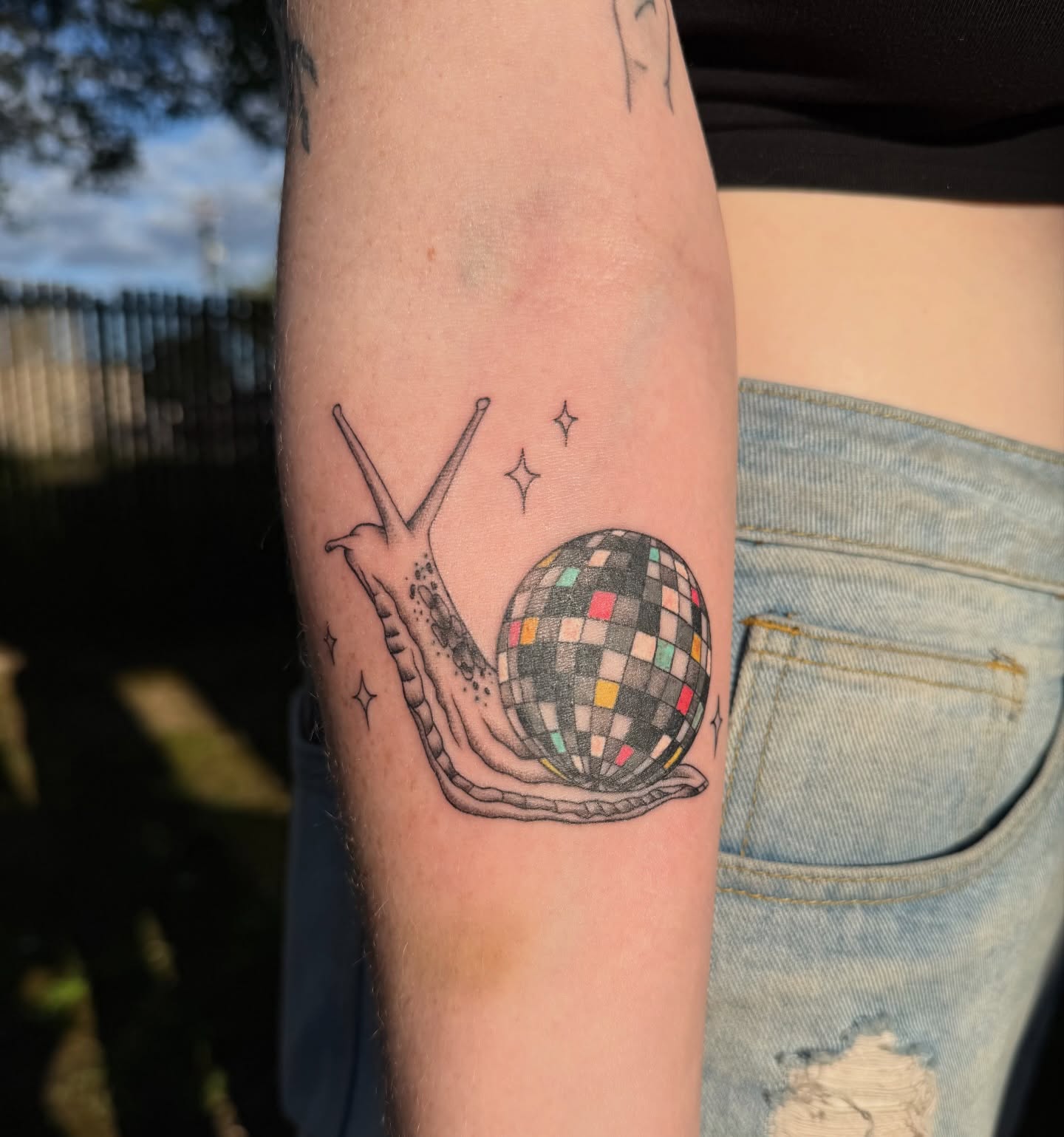 Snail with disco ball geometric tattoo on the forearm by Jenna Nicole