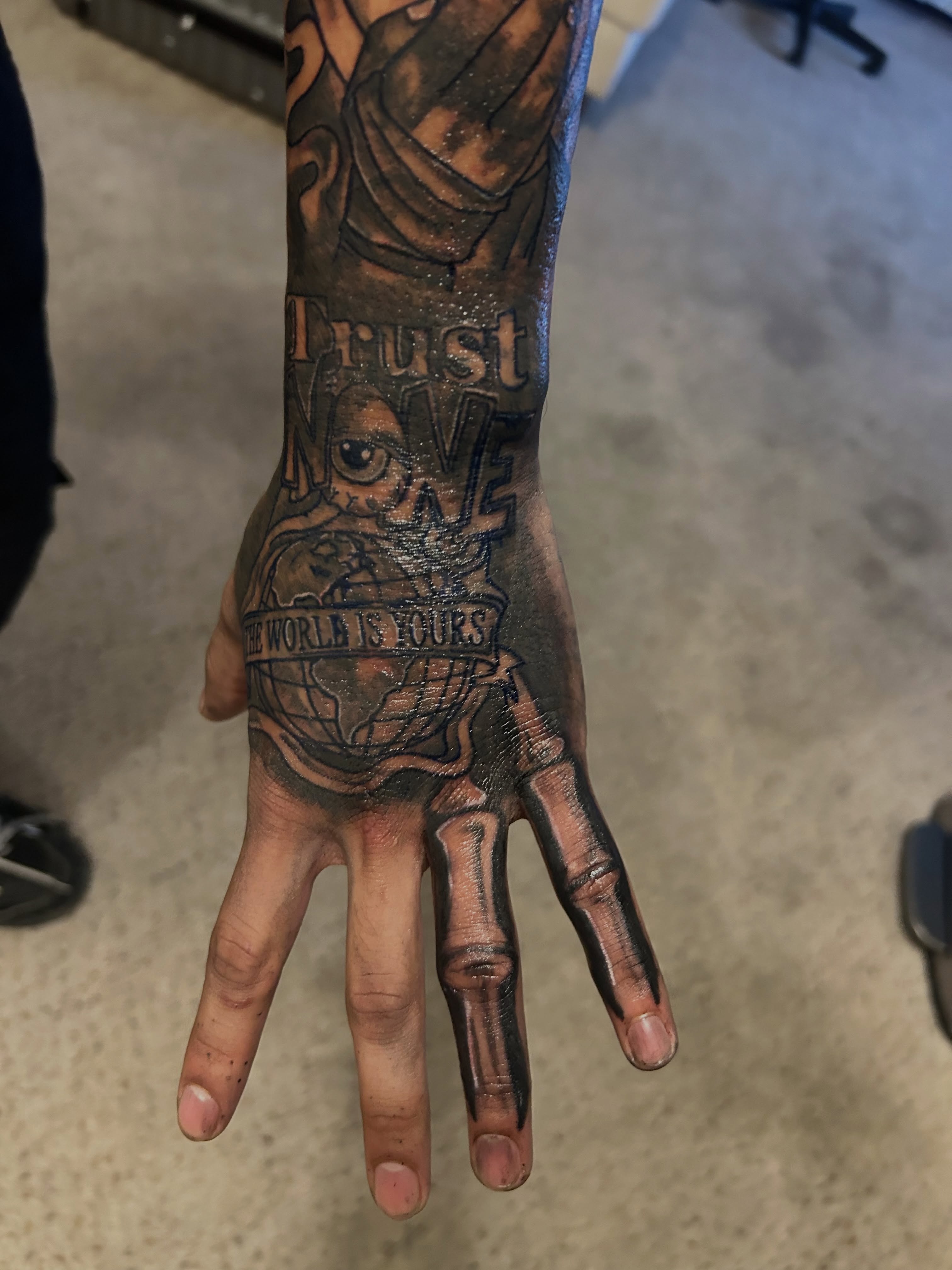 World map black and grey tattoo on the hand by @tatzbythadon