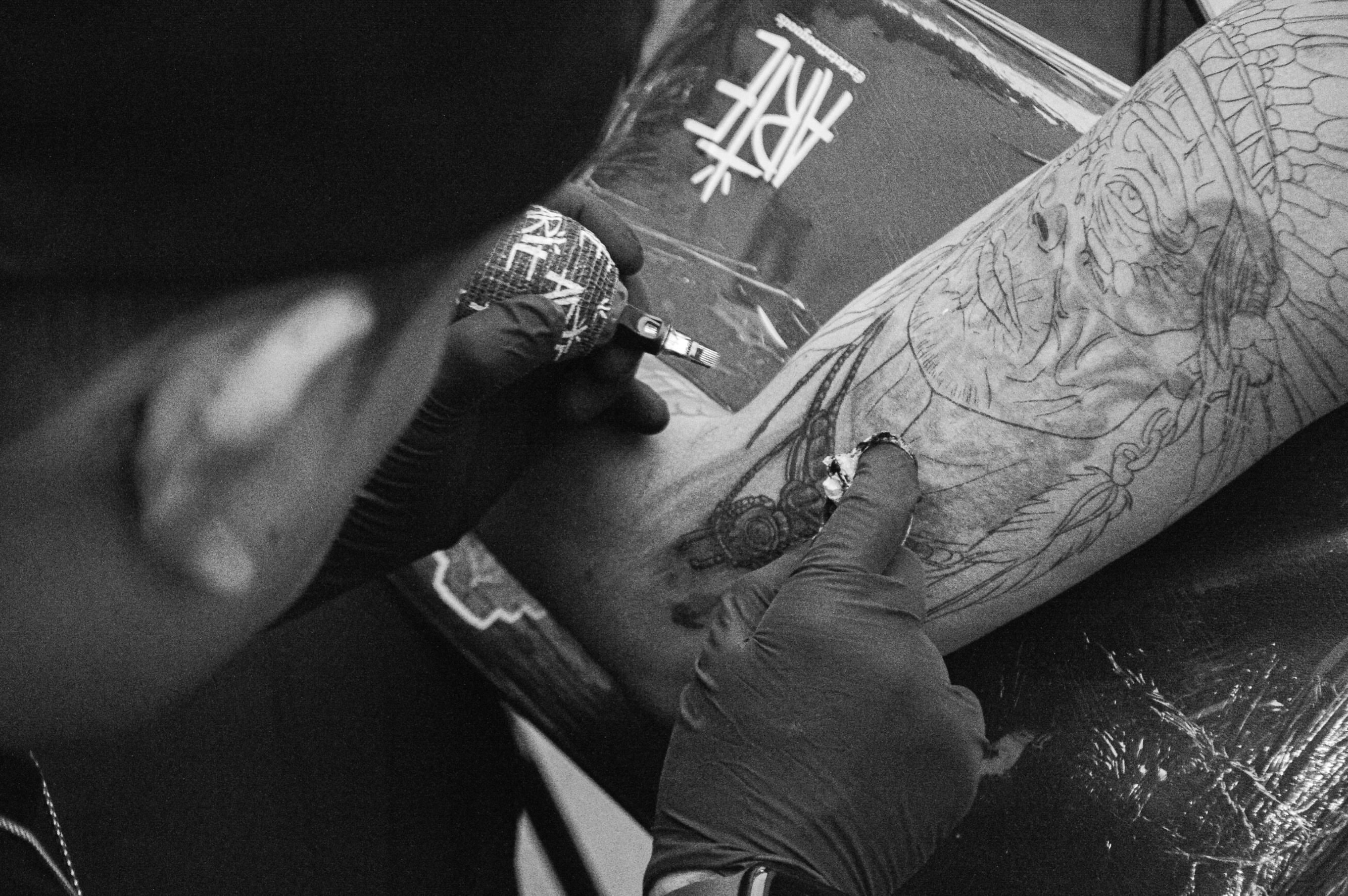 Mask black and grey tattoo on the forearm by Andres Flores