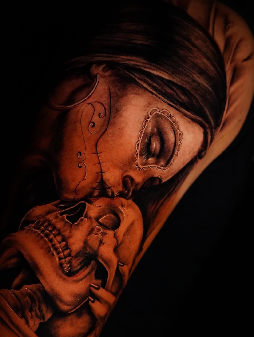Woman kissing skull realism tattoo on the forearm by Jennifer Garcia