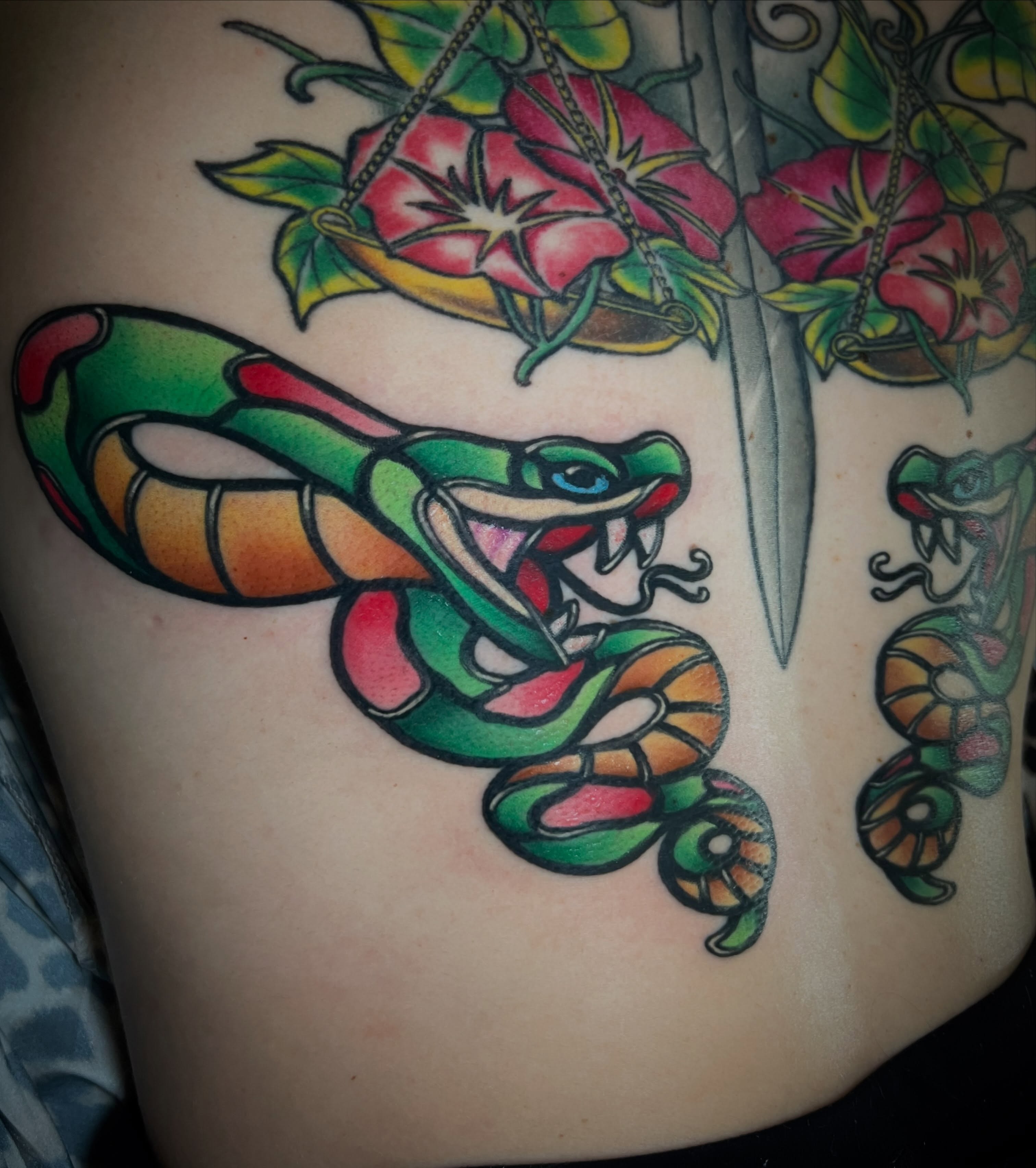 Snake and flowers American traditional tattoo on the shoulder by Katie Ann Tattoos