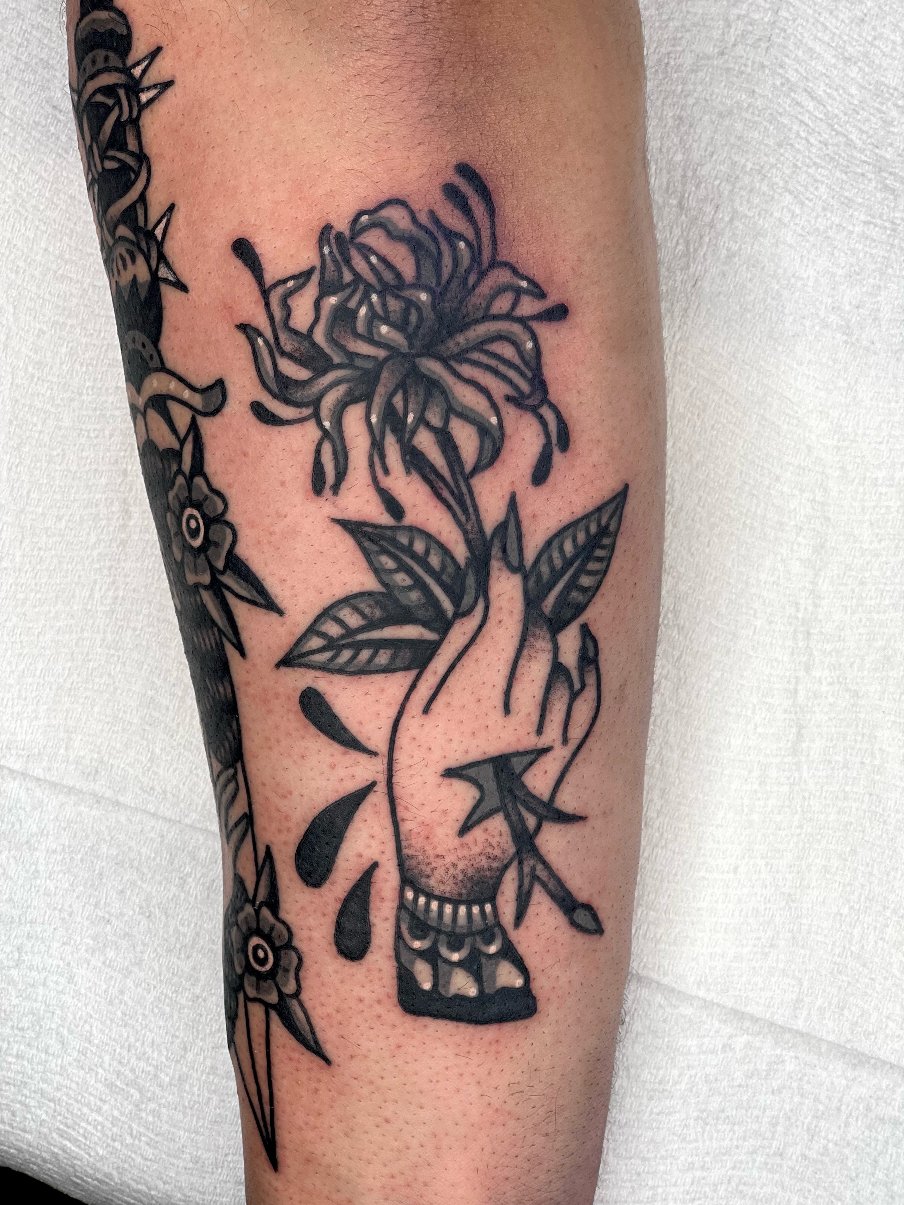 Chrysanthemum and hand American traditional tattoo on the forearm by Christopher Durao
