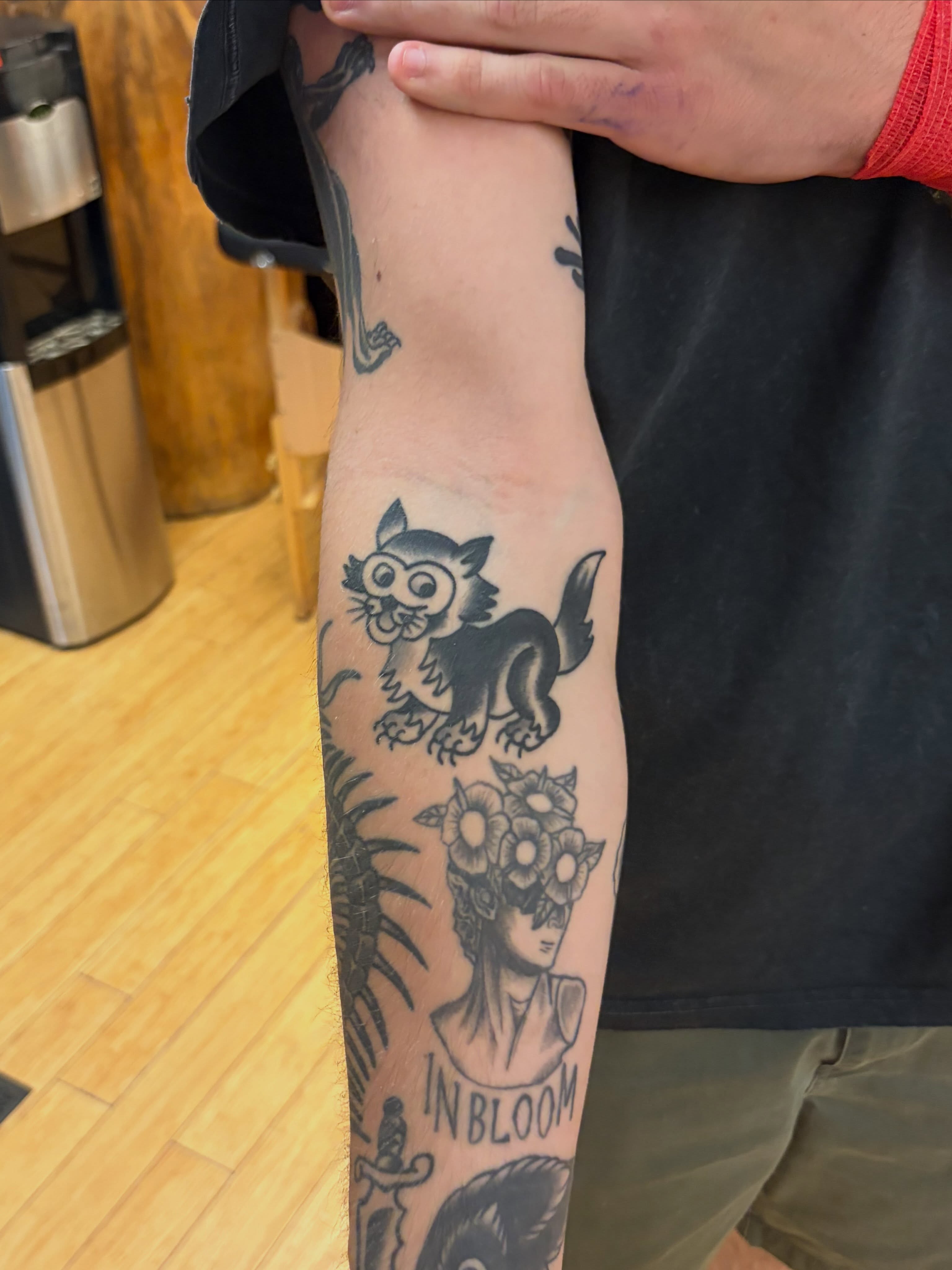 Cat and woman with flowers American traditional tattoo on the forearm by Nick Meerburg