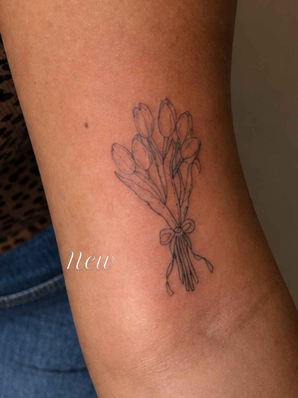 Bouquet of tulips fine line tattoo on the forearm by Victoria Cooper