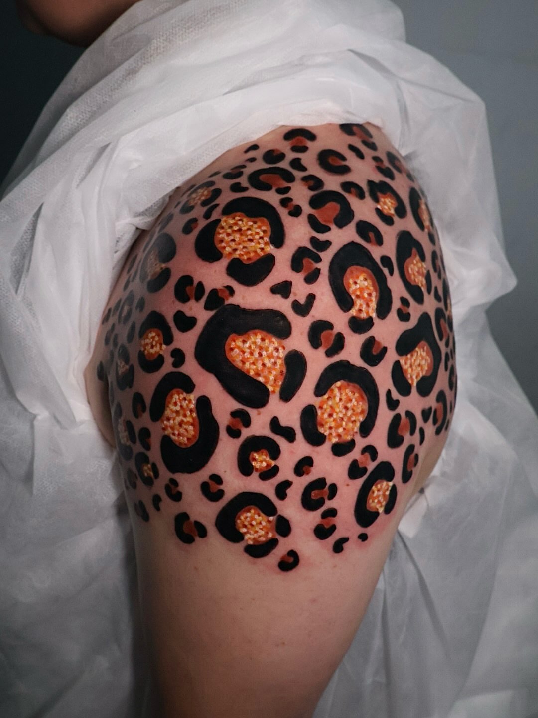 Leopard print dotwork tattoo on the shoulder by Bailey Drey