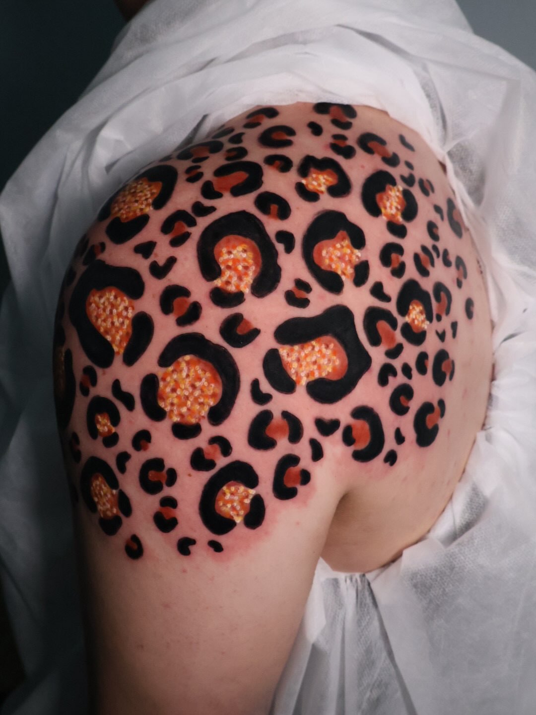Leopard print dotwork tattoo on the shoulder by Bailey Drey