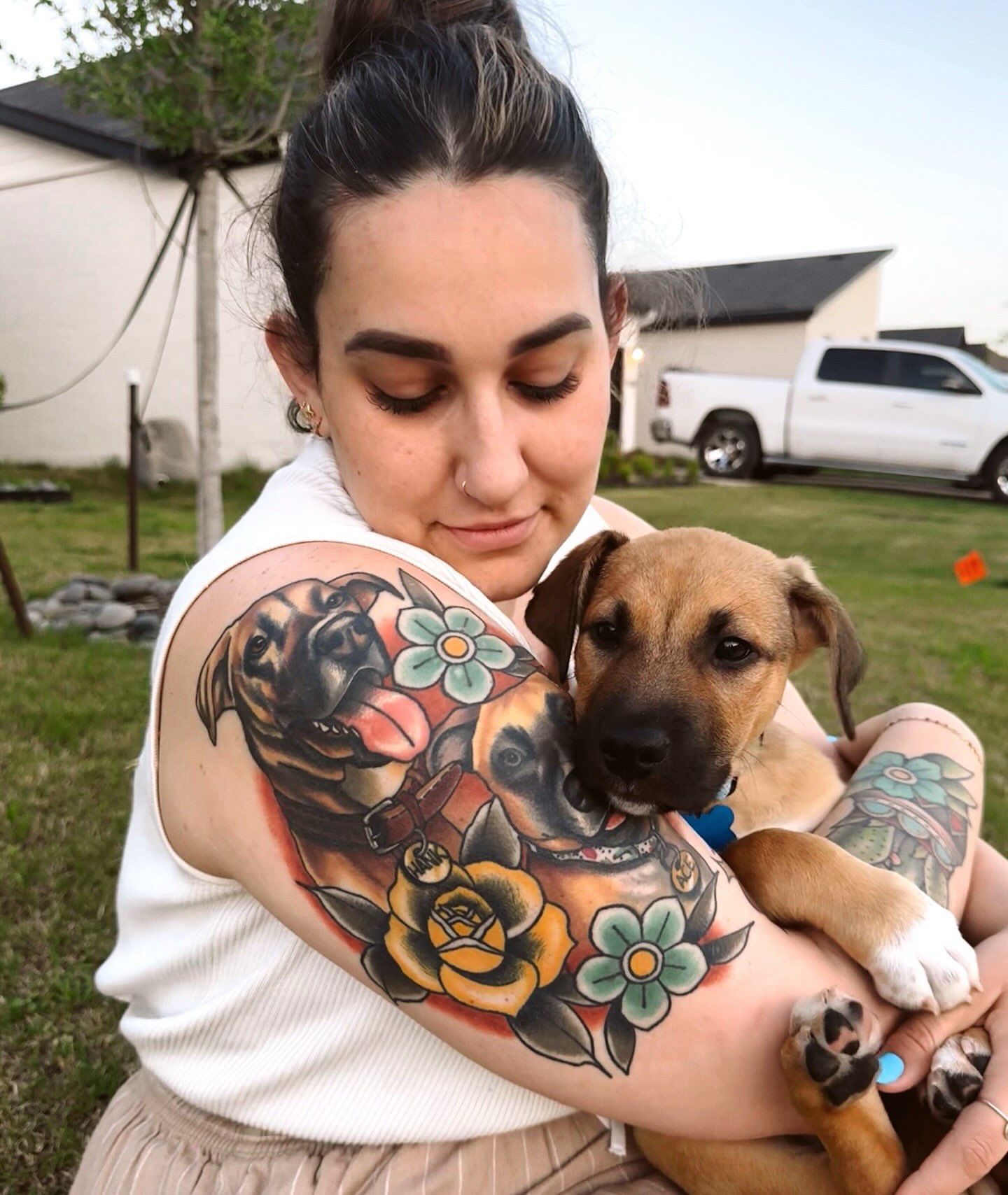 Dogs and flowers American traditional tattoo on the upper arm by Liz McDonald
