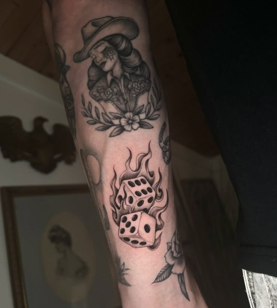 Flaming dice American traditional tattoo on the forearm by Emma Cotter