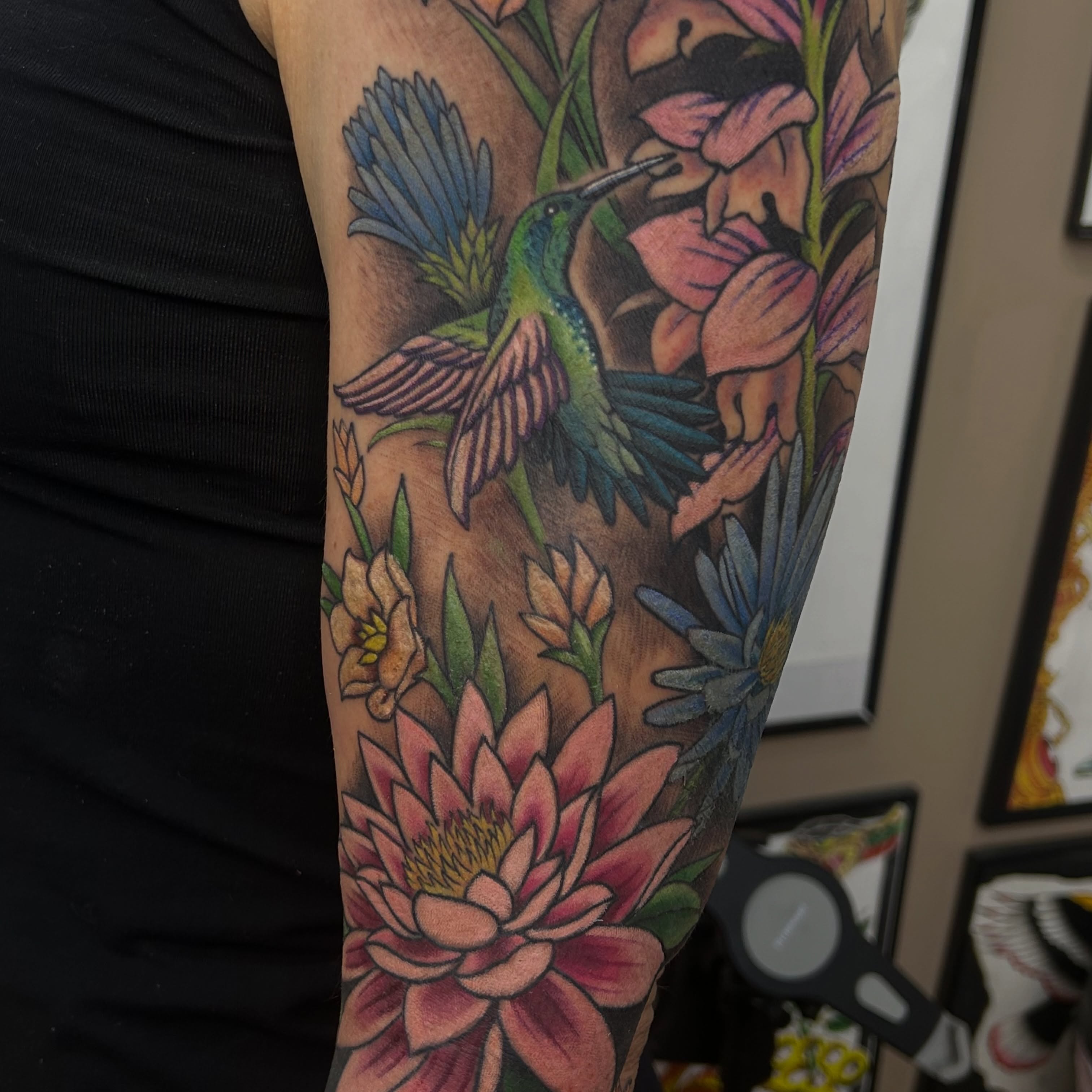 Hummingbird and flowers realism tattoo on the forearm by Alex Byrne