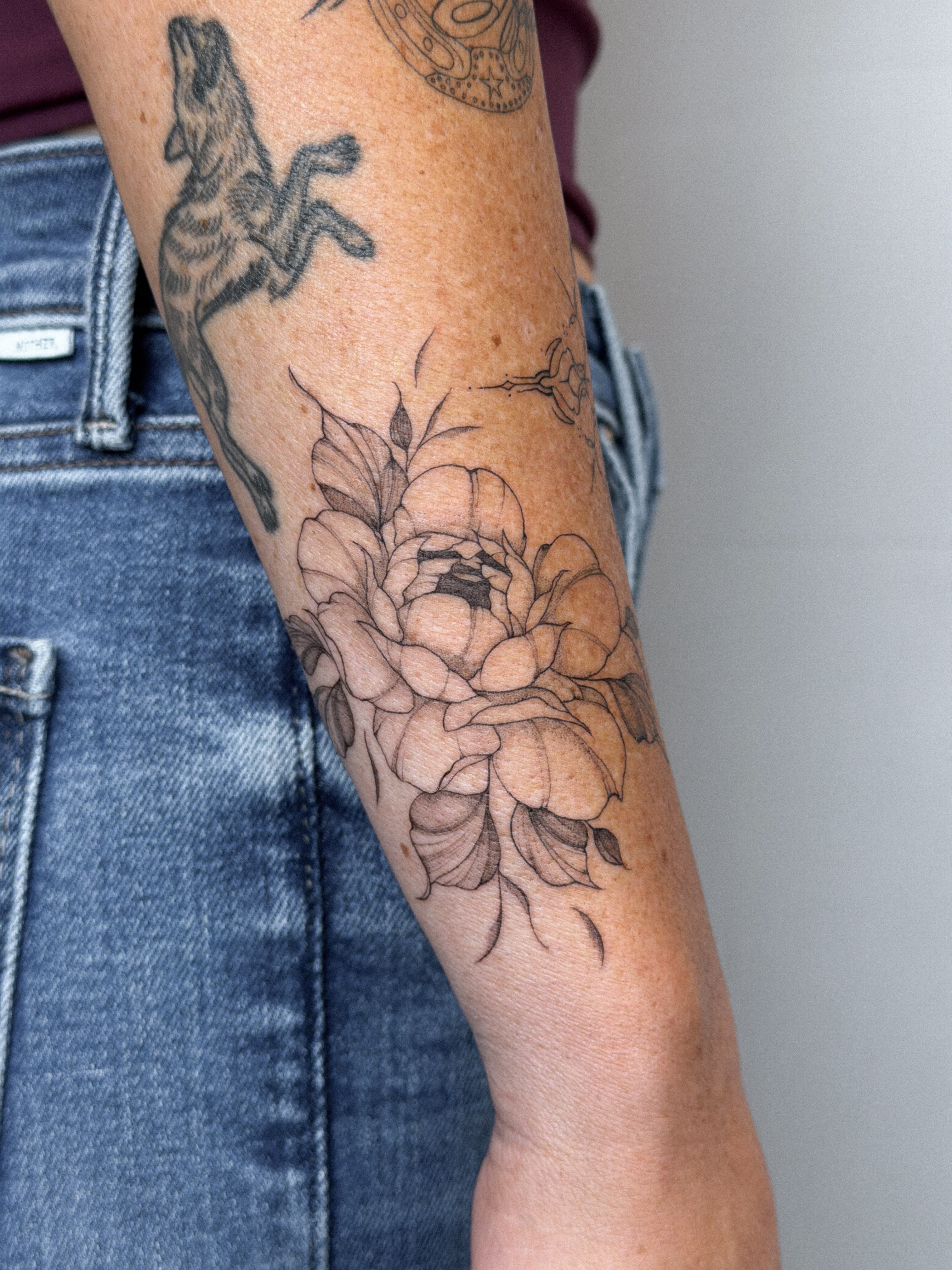 Peony black and grey tattoo on the forearm by Hannah Matthews
