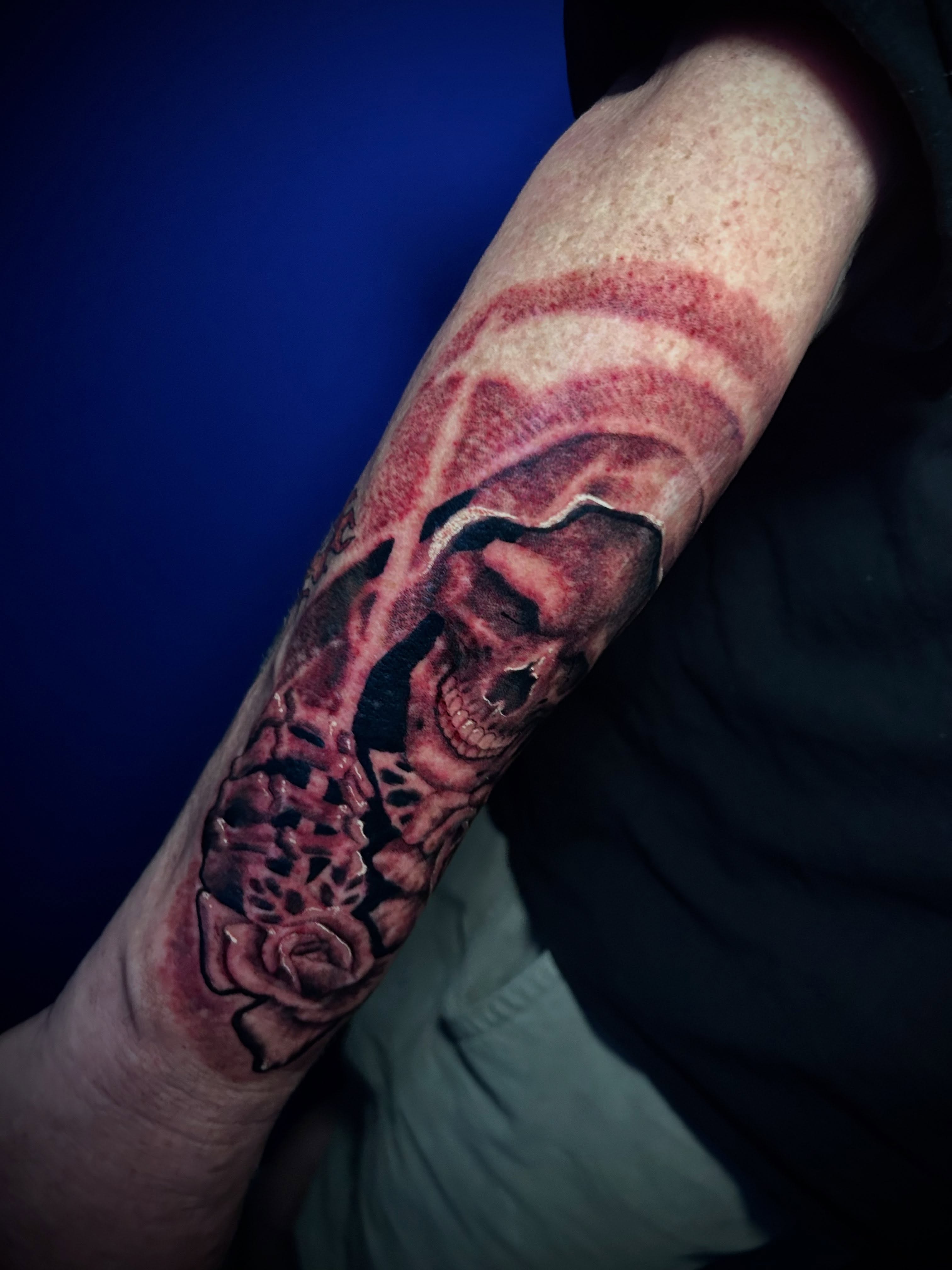 Skull and roses realism tattoo on the forearm by Adrian Michigan Tattoo Artist