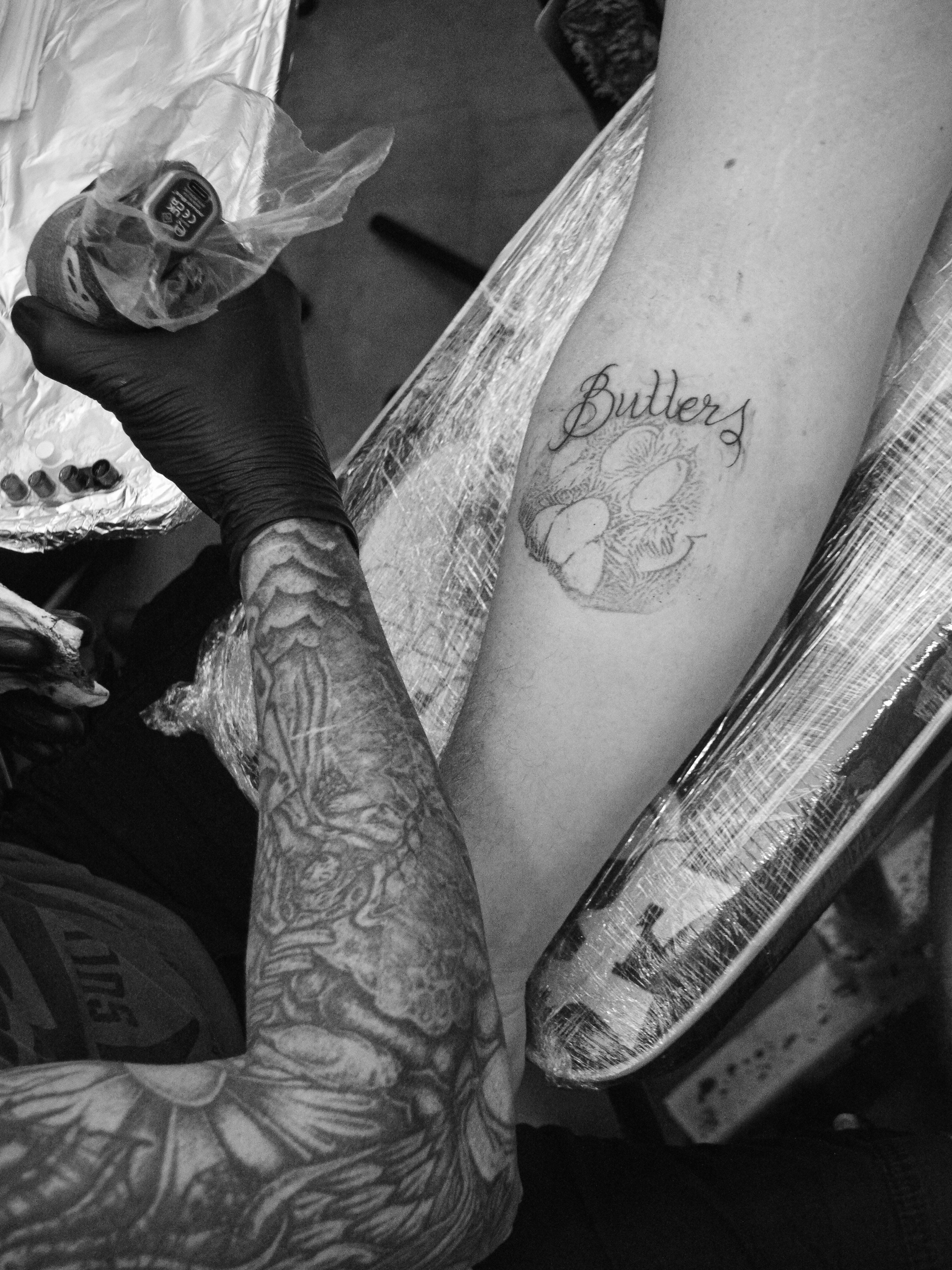 Flower and script black and grey tattoo on the forearm by Andres Flores