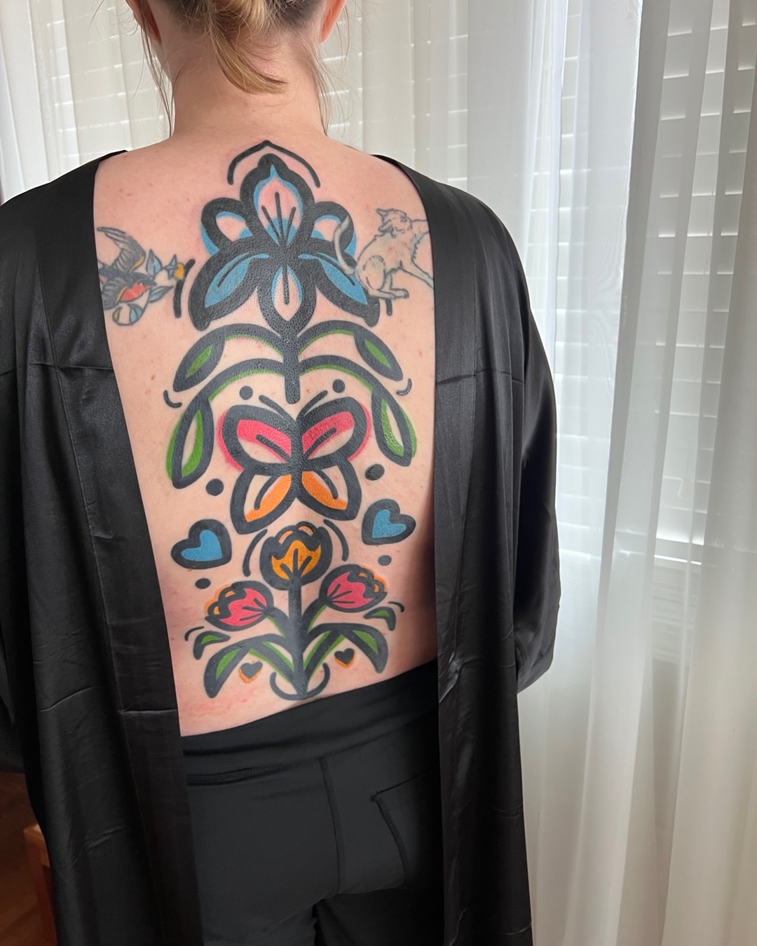Floral arrangement new school tattoo on the back by Tattoo Artist