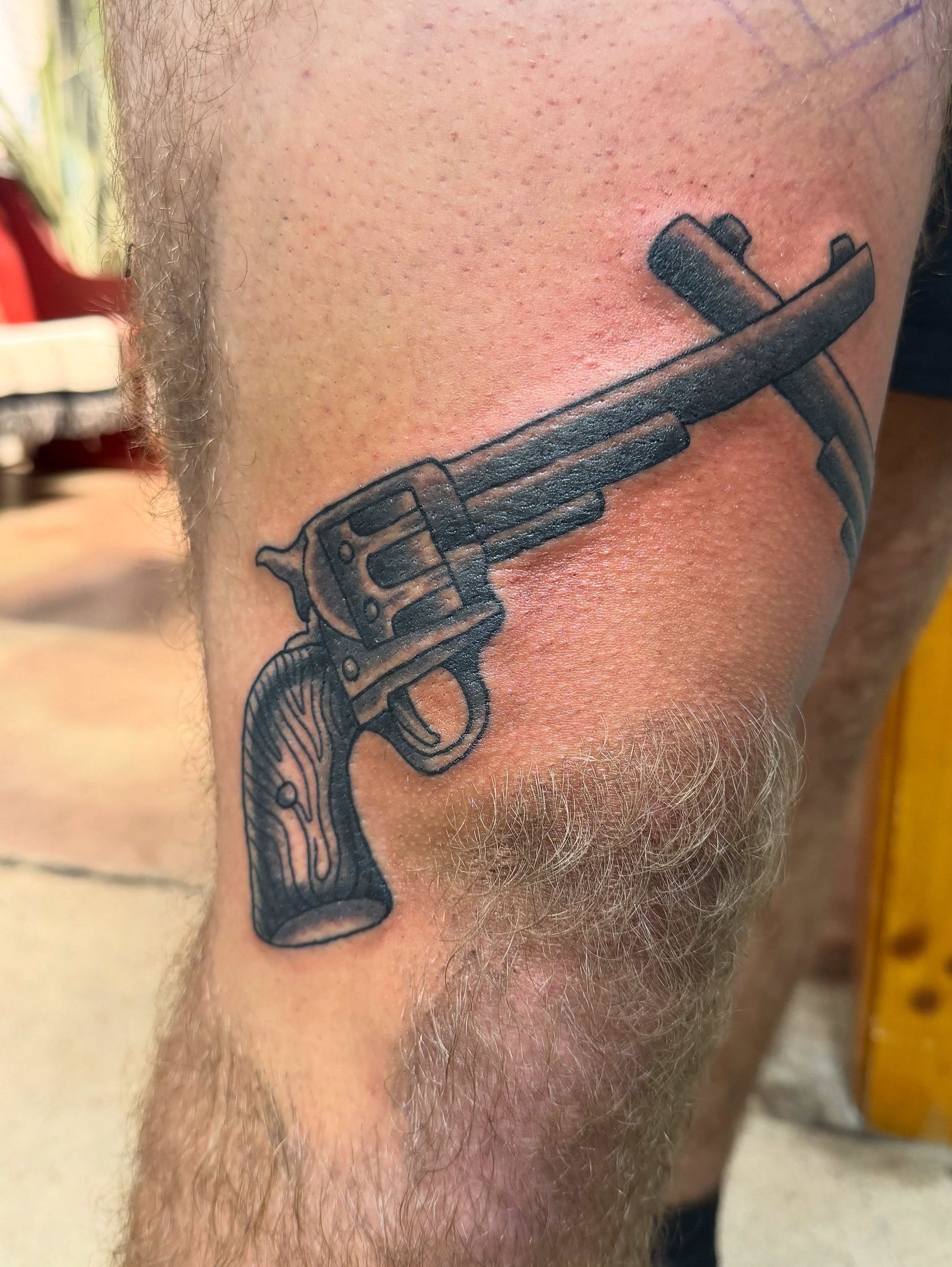 Revolver black and grey tattoo on the thigh by Spencer Coco