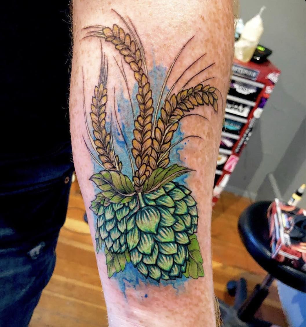 Wheat and hops watercolor tattoo on the forearm by Josh O’ + Bird ☘️ 🪶