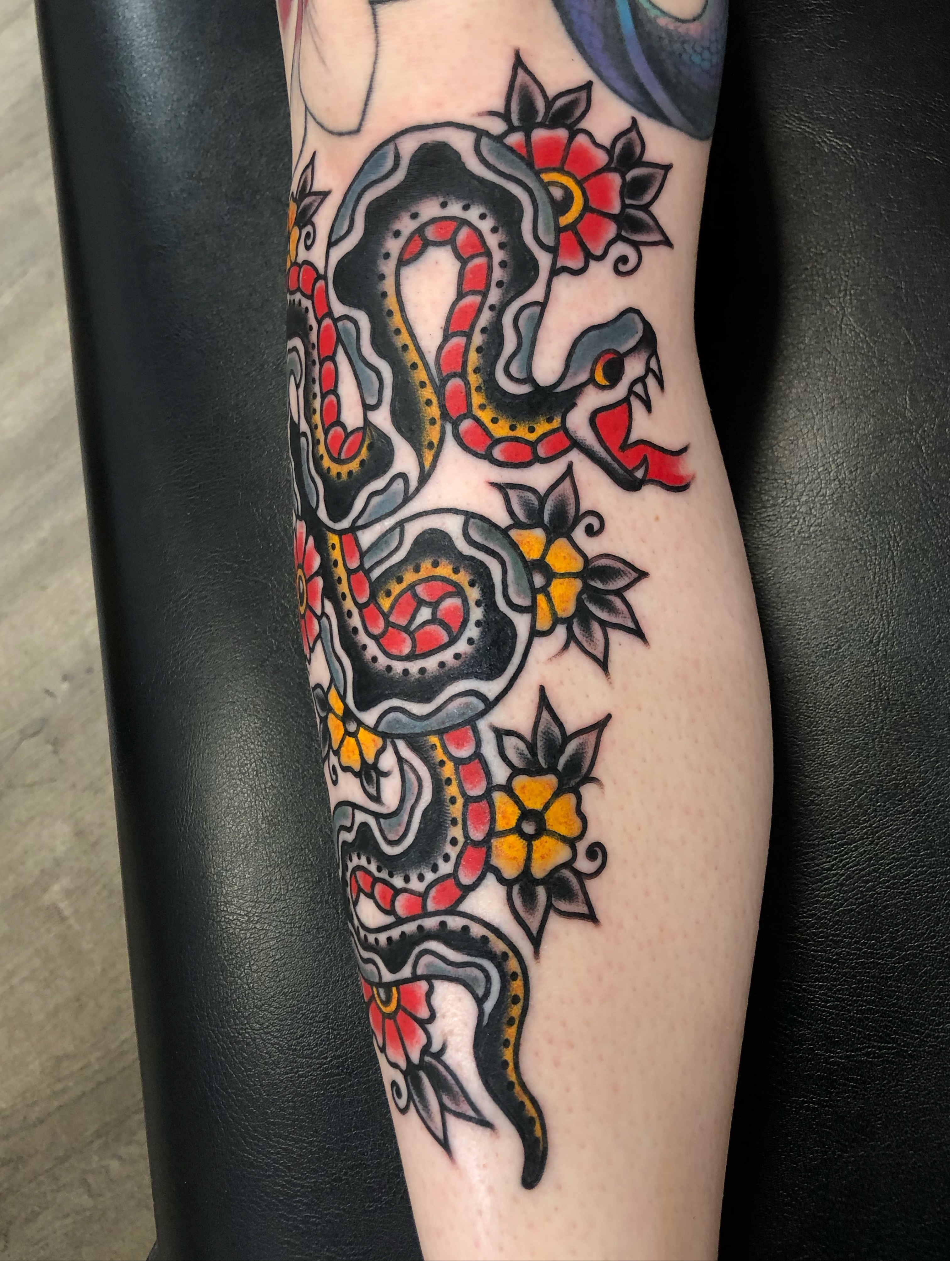 Snake and flowers American traditional tattoo on the forearm by Nick Sharratt, Chicago, Illinois