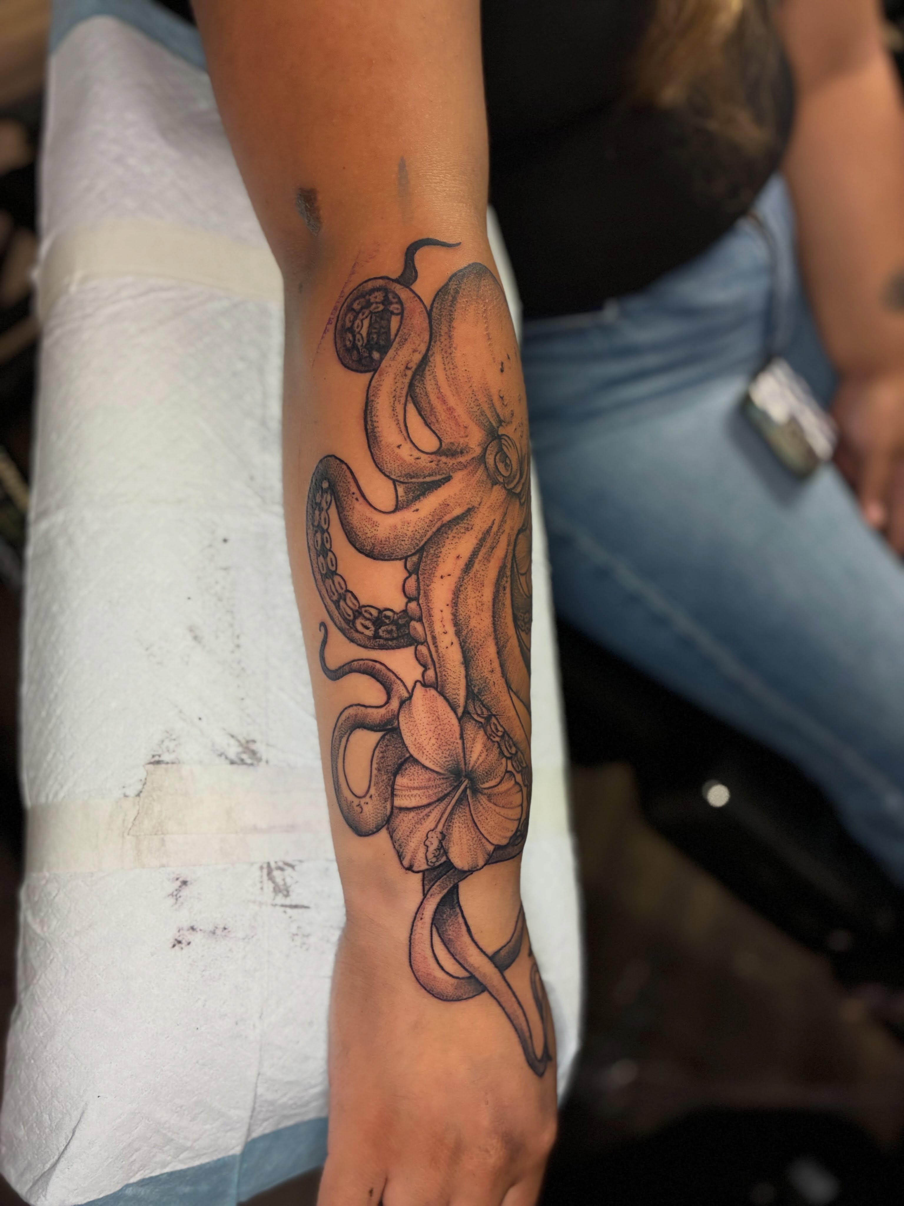 Octopus and hibiscus dotwork tattoo on the forearm by Kevin Strong