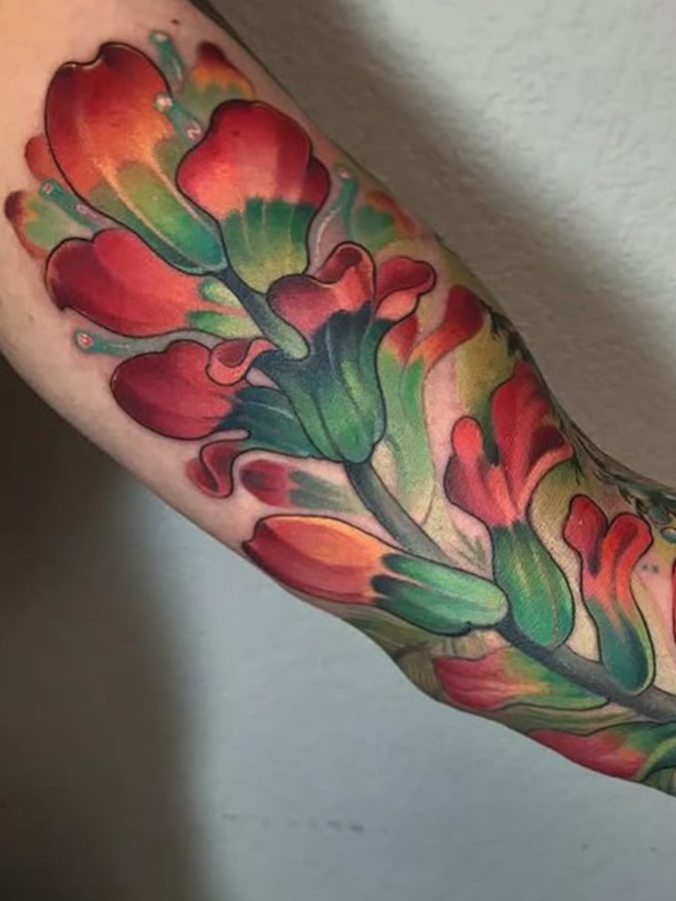Flowers watercolor tattoo on the forearm by Melis Fusco
