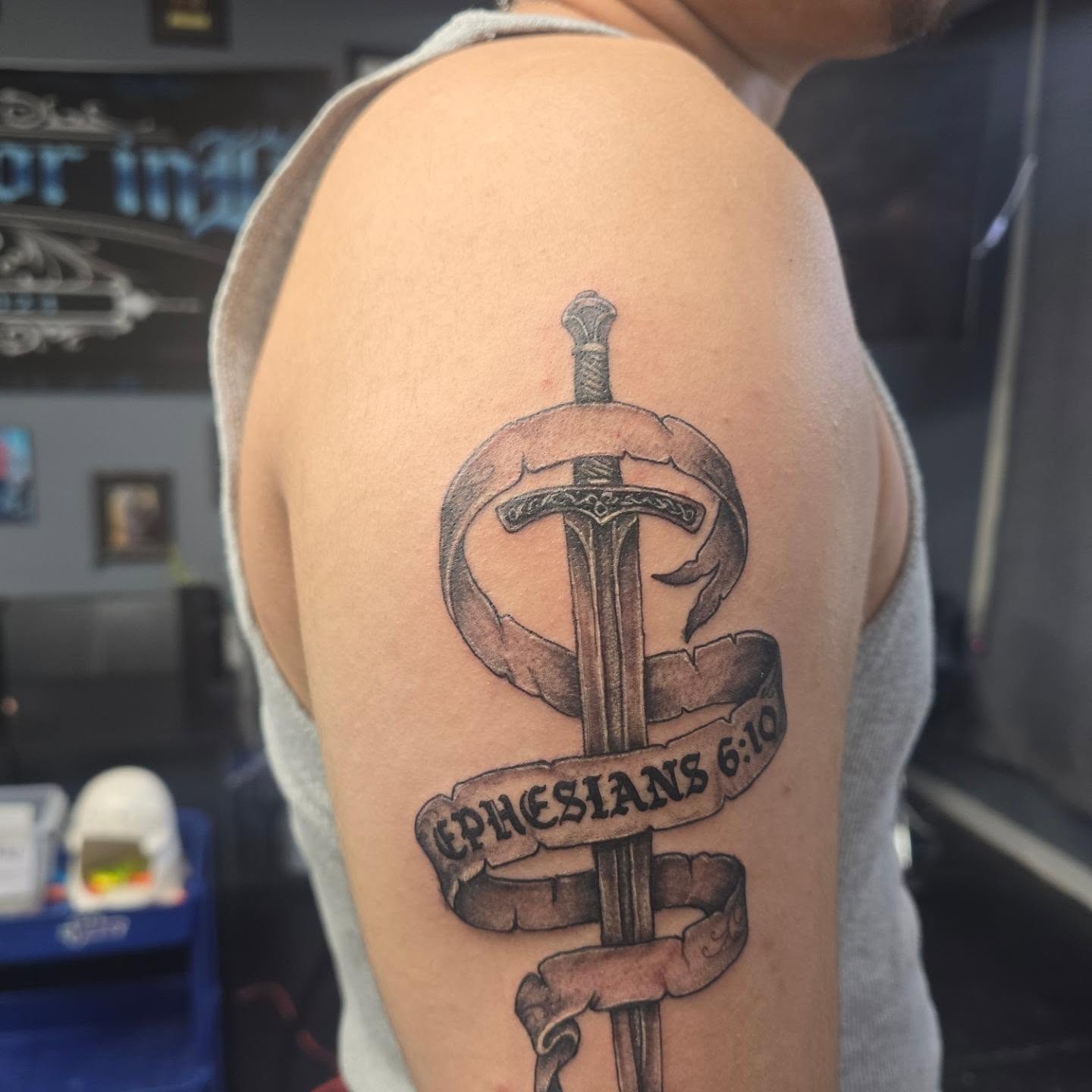 Sword and ribbon black and grey tattoo on the shoulder by Maddox Kitson🕷