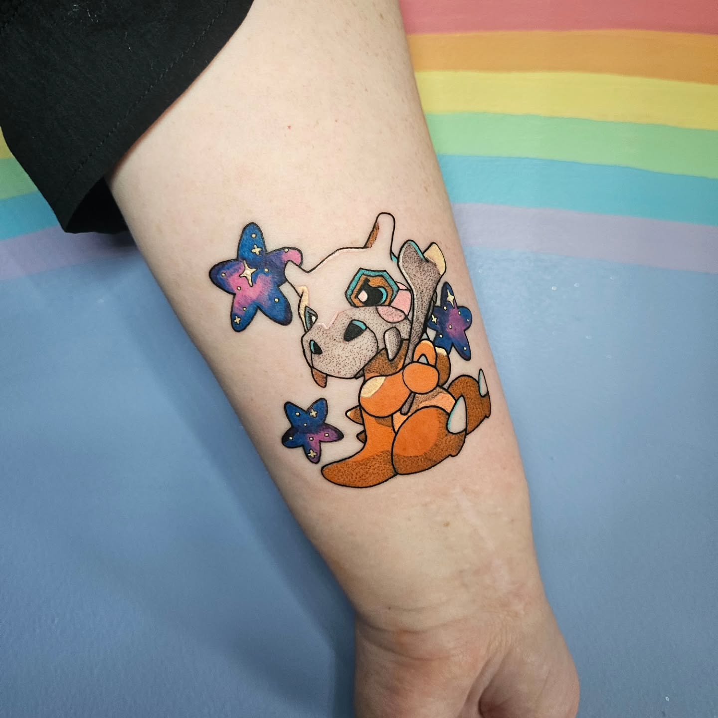 Dinosaur with stars dotwork tattoo on the forearm by Gray