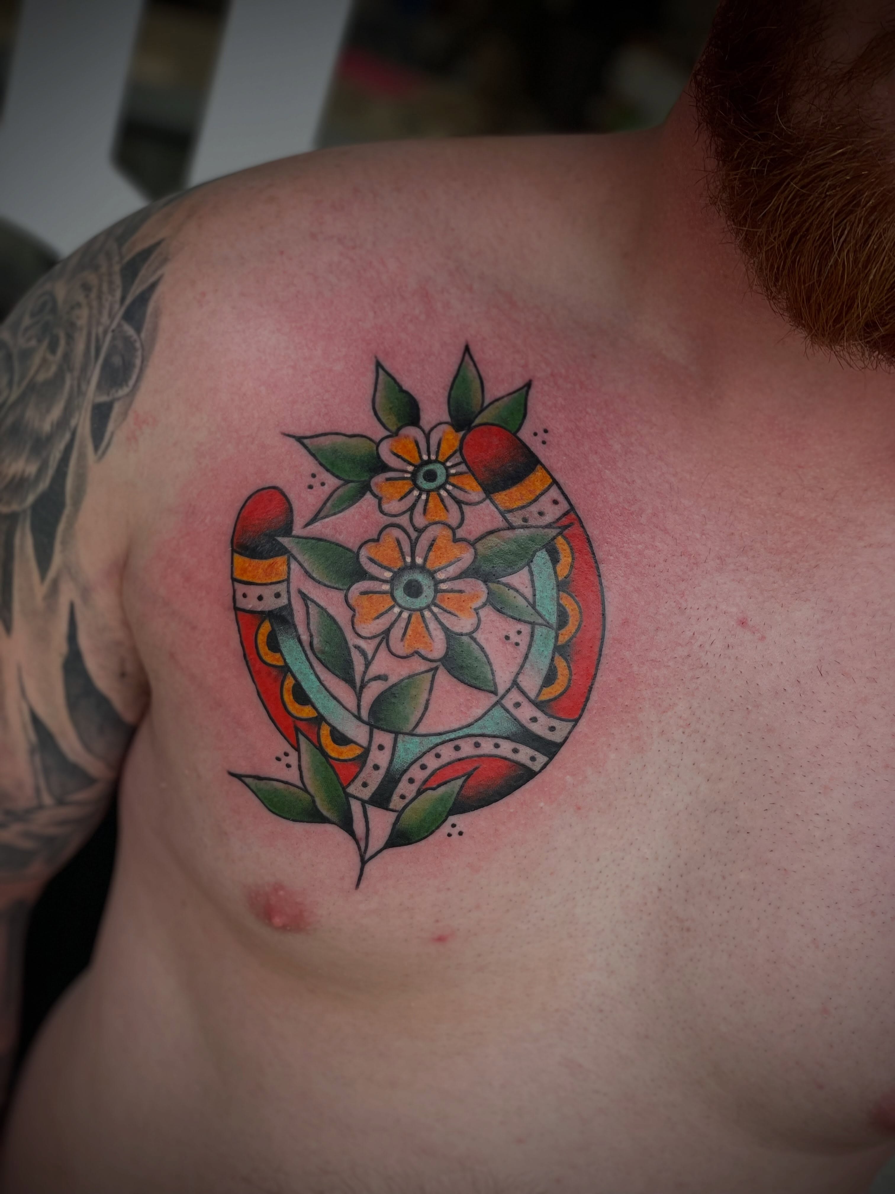 Flower and horseshoe American traditional tattoo on the shoulder by Dave Kruseman