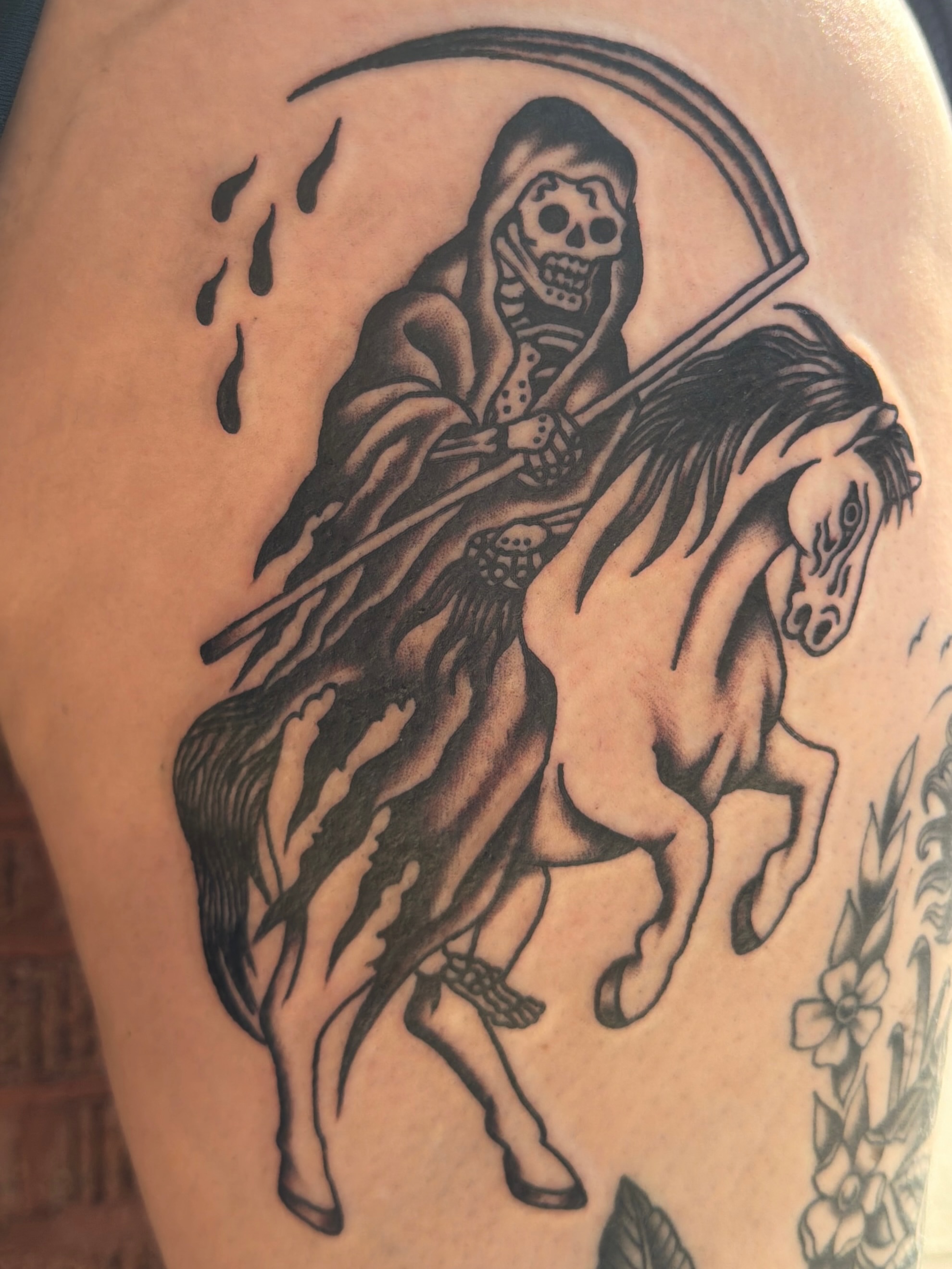 Grim reaper on horseback black and grey tattoo on the thigh by Emma Fox Tattoo