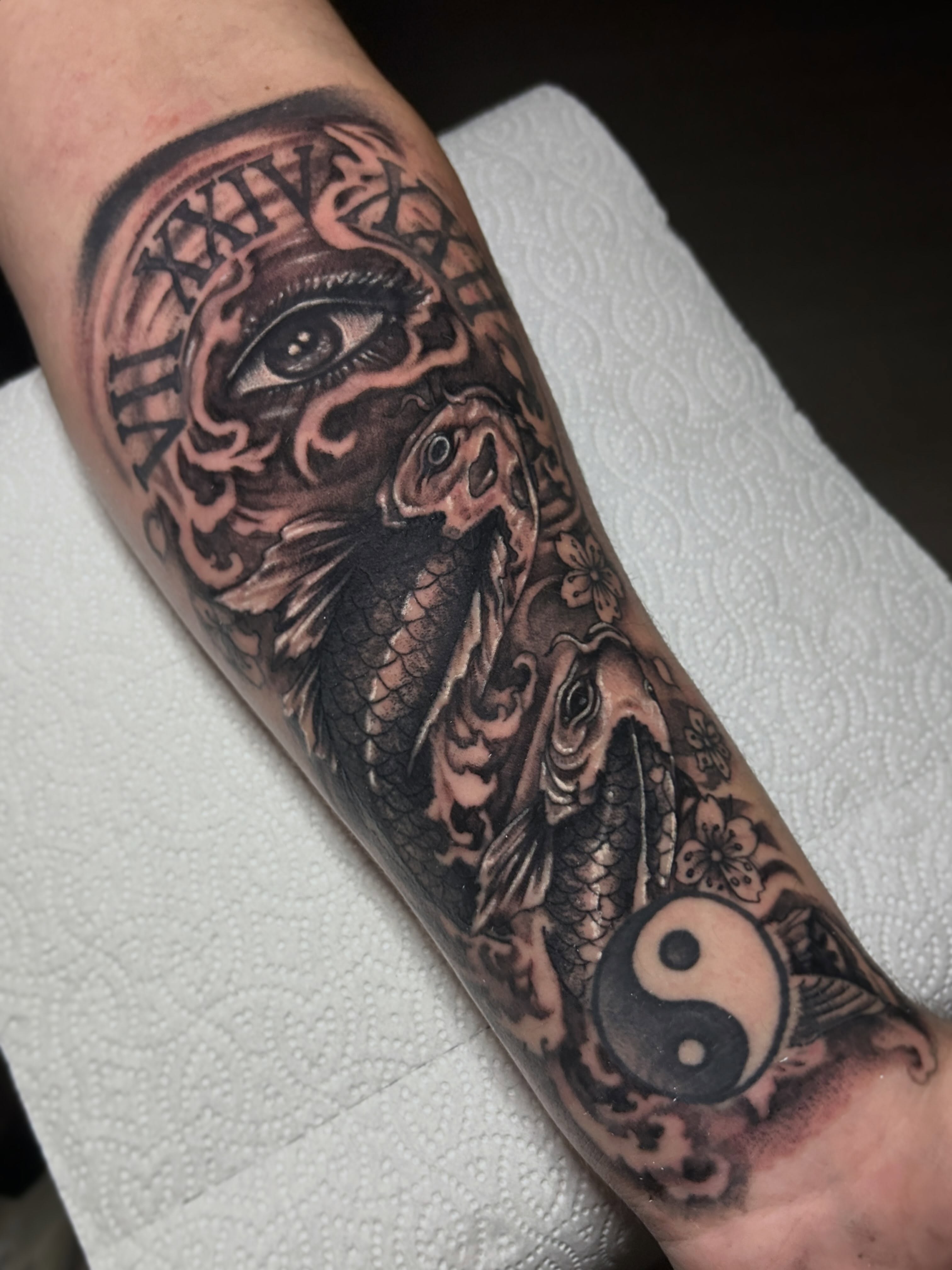 Koi fish and yin-yang black and grey tattoo on the forearm by Marky