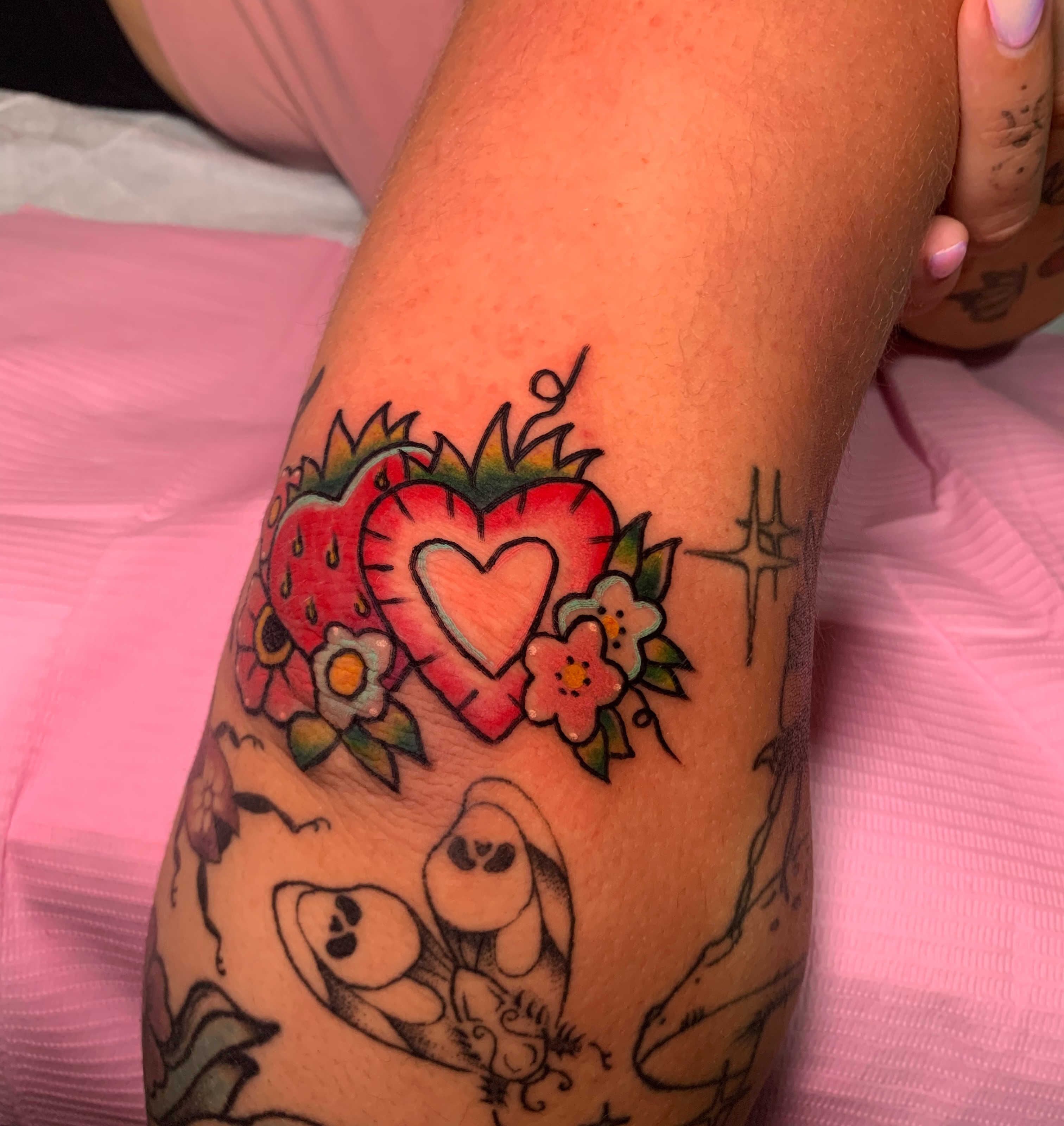 Heart and strawberries American traditional tattoo on the forearm by Aubrianna Grisez