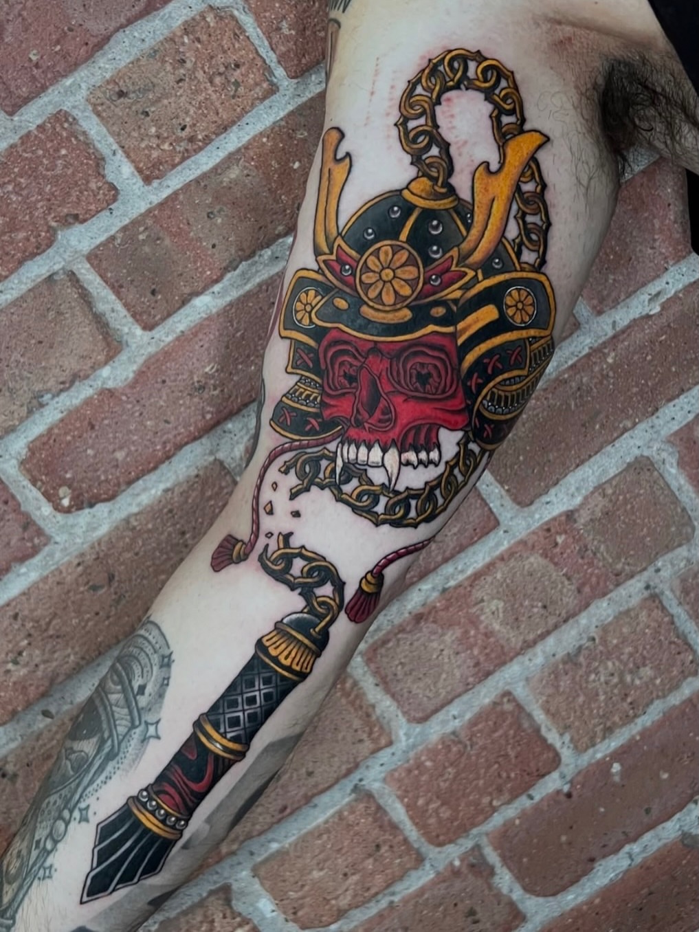 Skull with ornate headdress American traditional tattoo on the forearm by Eoghann McGregor
