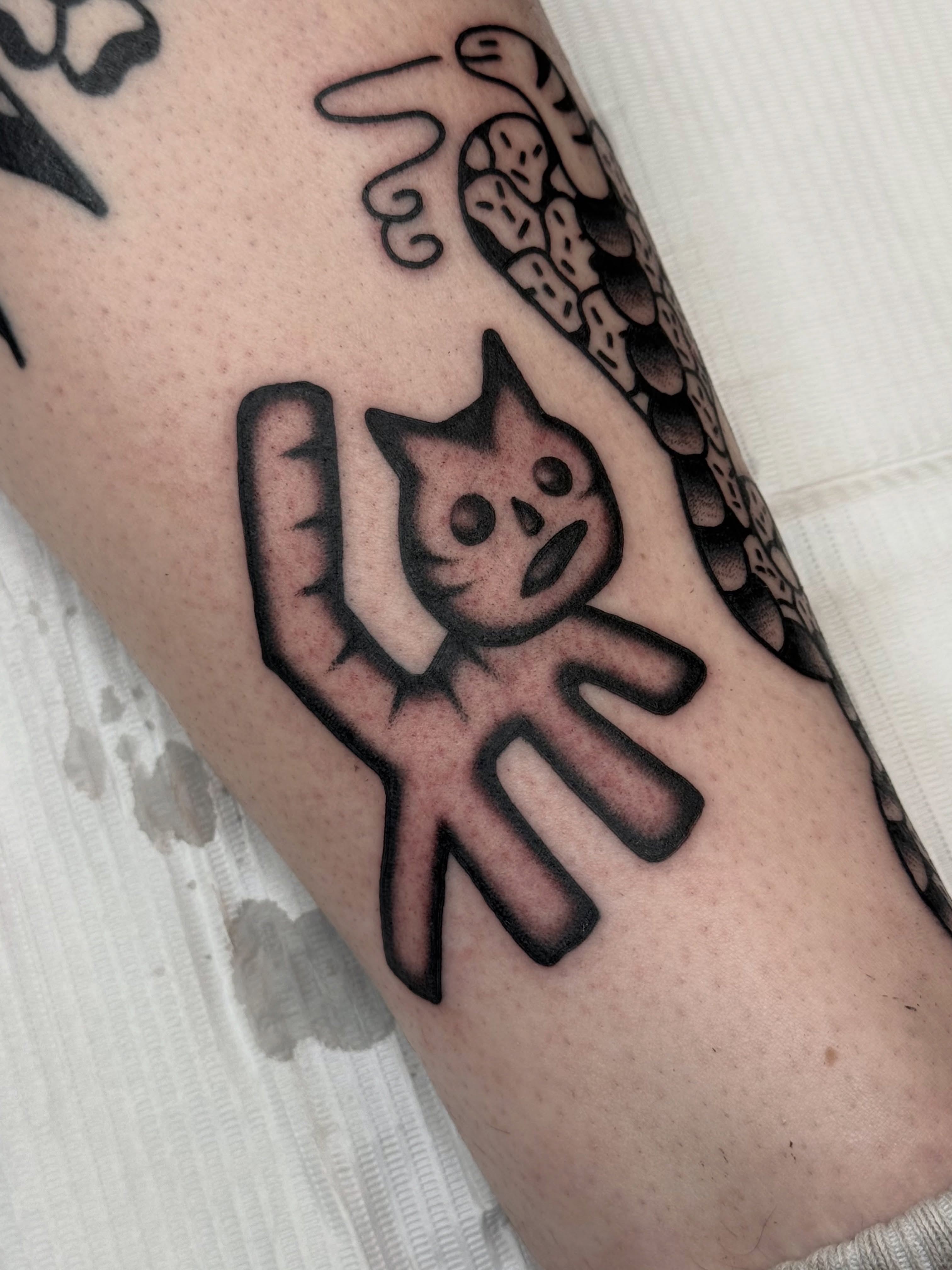 Cat black and grey tattoo on the forearm by Roman