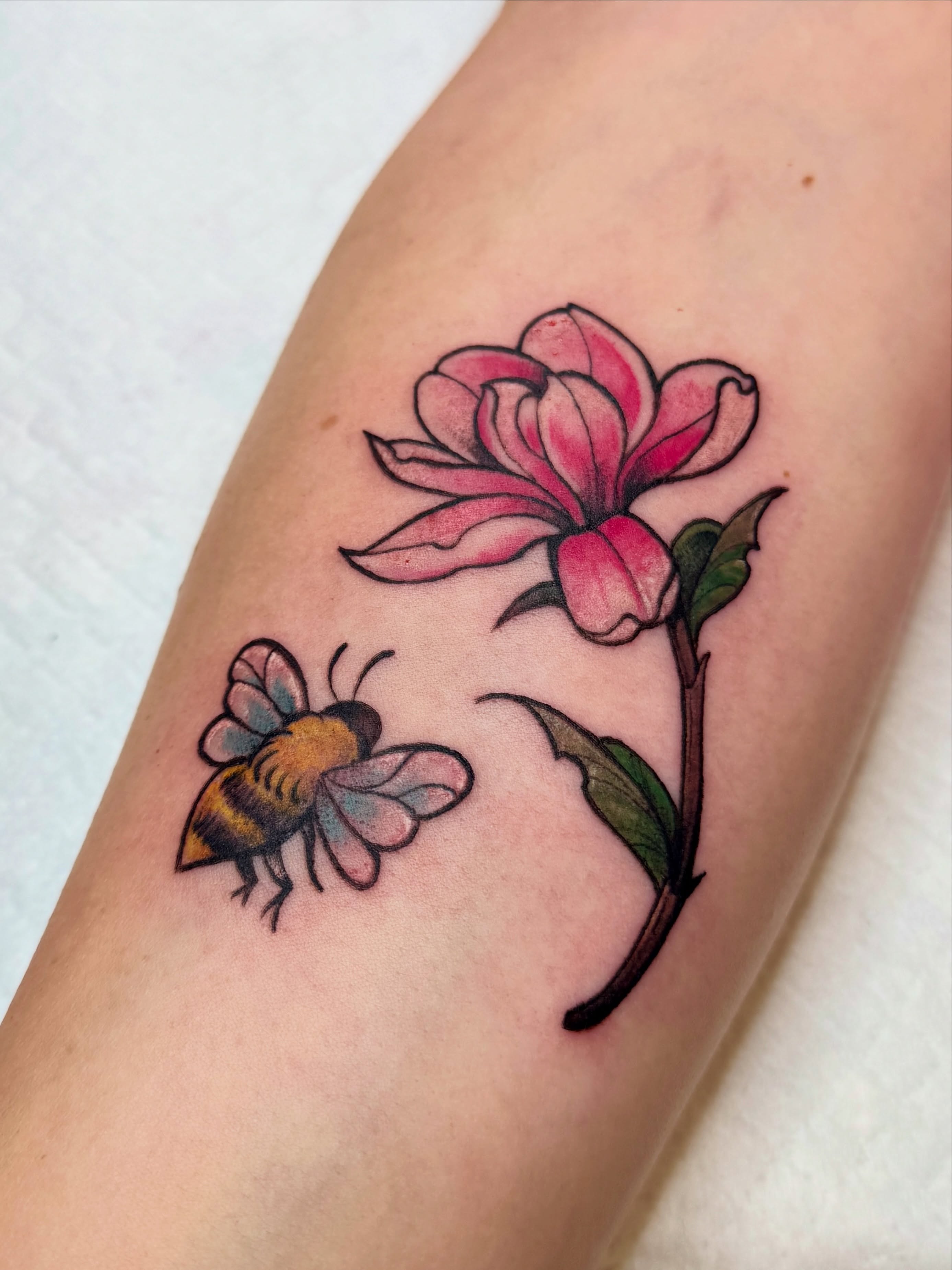 Magnolia and bee American traditional tattoo on the forearm by Andy Rowe- Tattoo Artist🦇