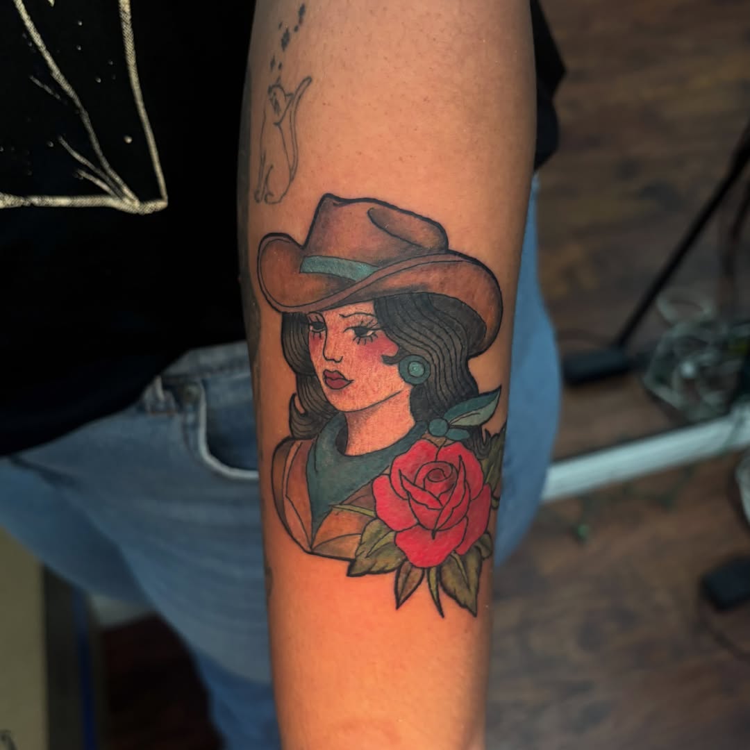 Cowgirl with rose American traditional tattoo on the forearm by Emma ๐
