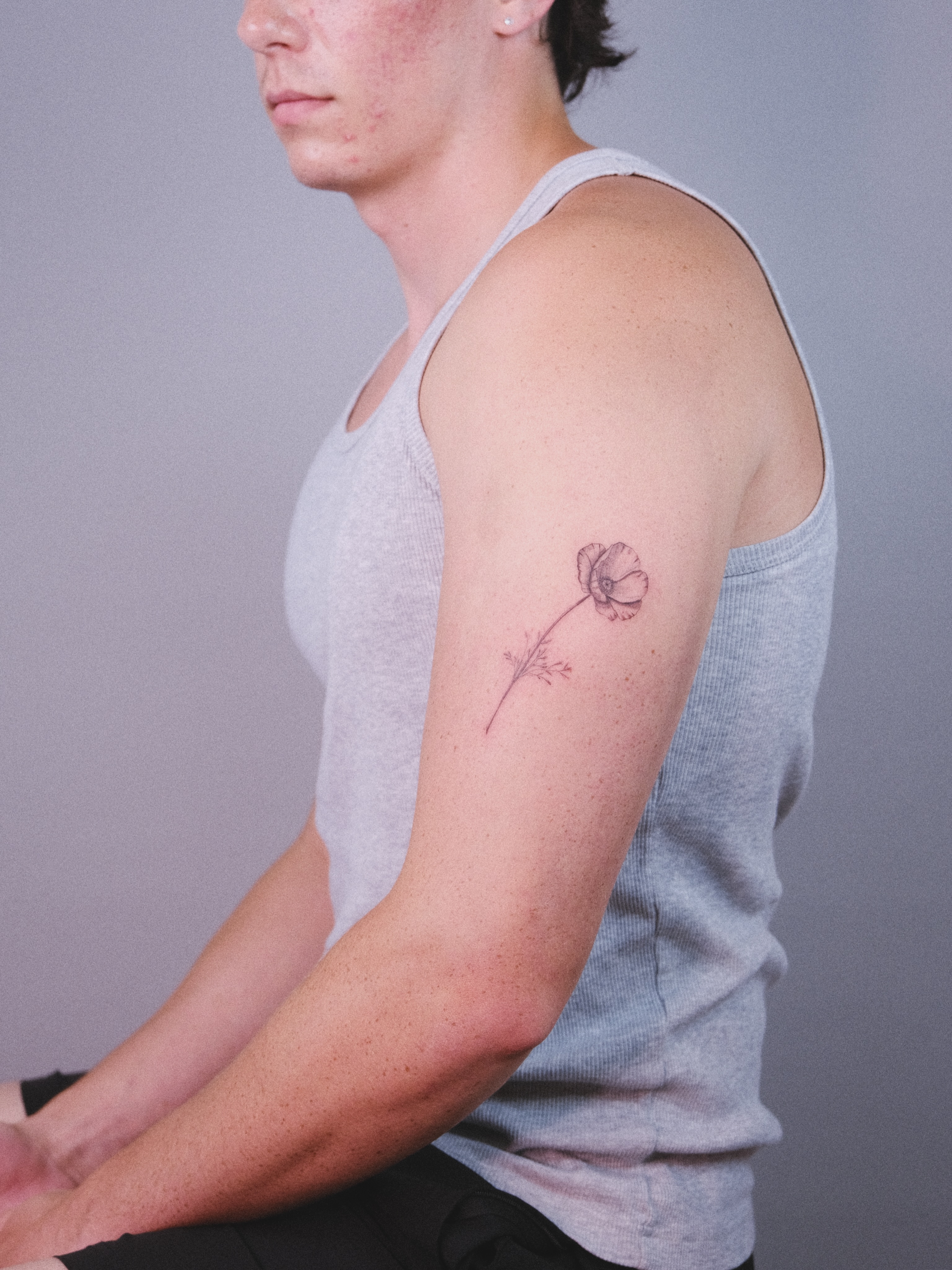 Flower black and grey tattoo on the upper arm by Anna
