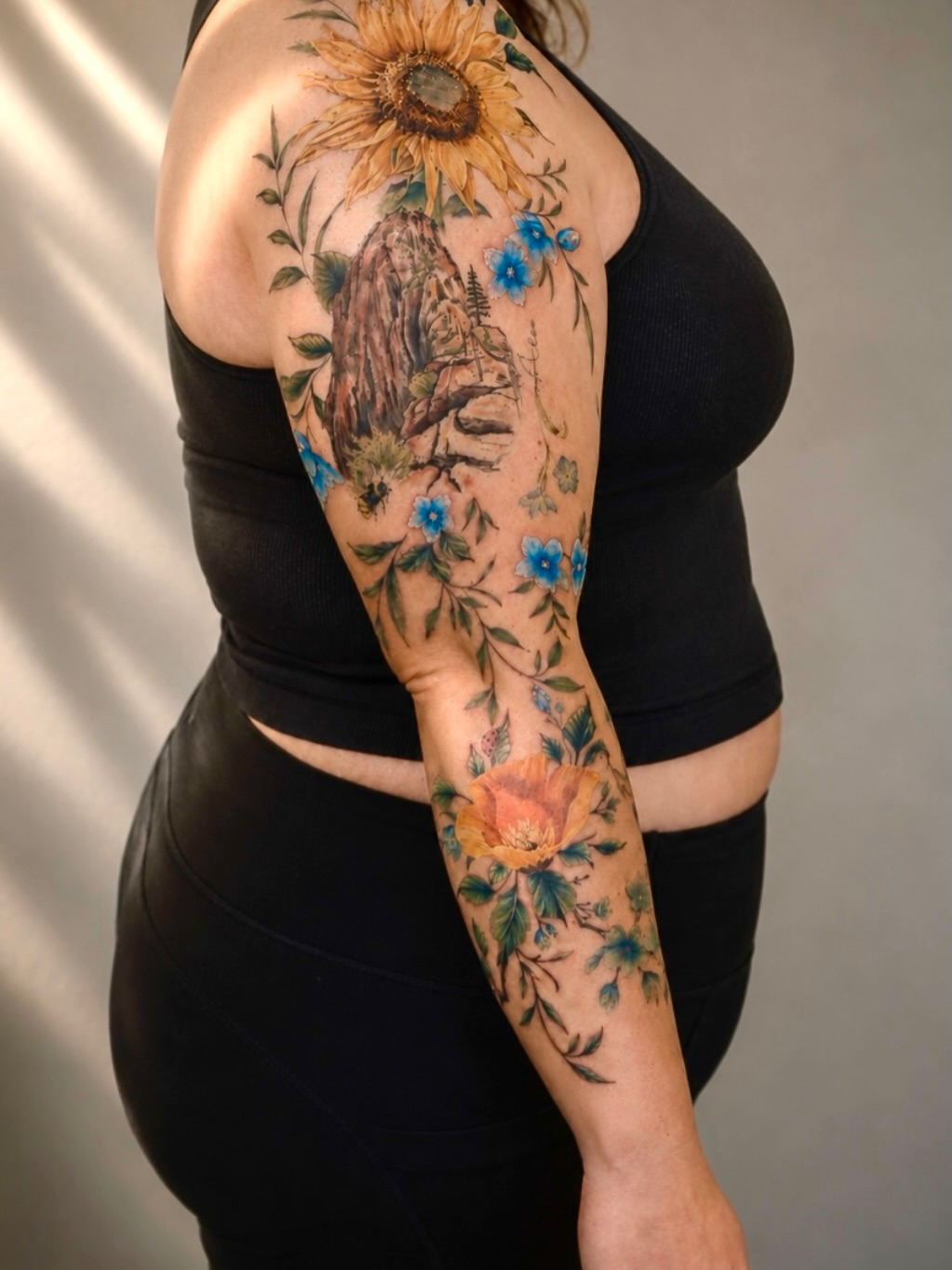 Sunflower and mountain realism tattoo on the upper arm by Adam_Zhiwei Xu(Tattooist)