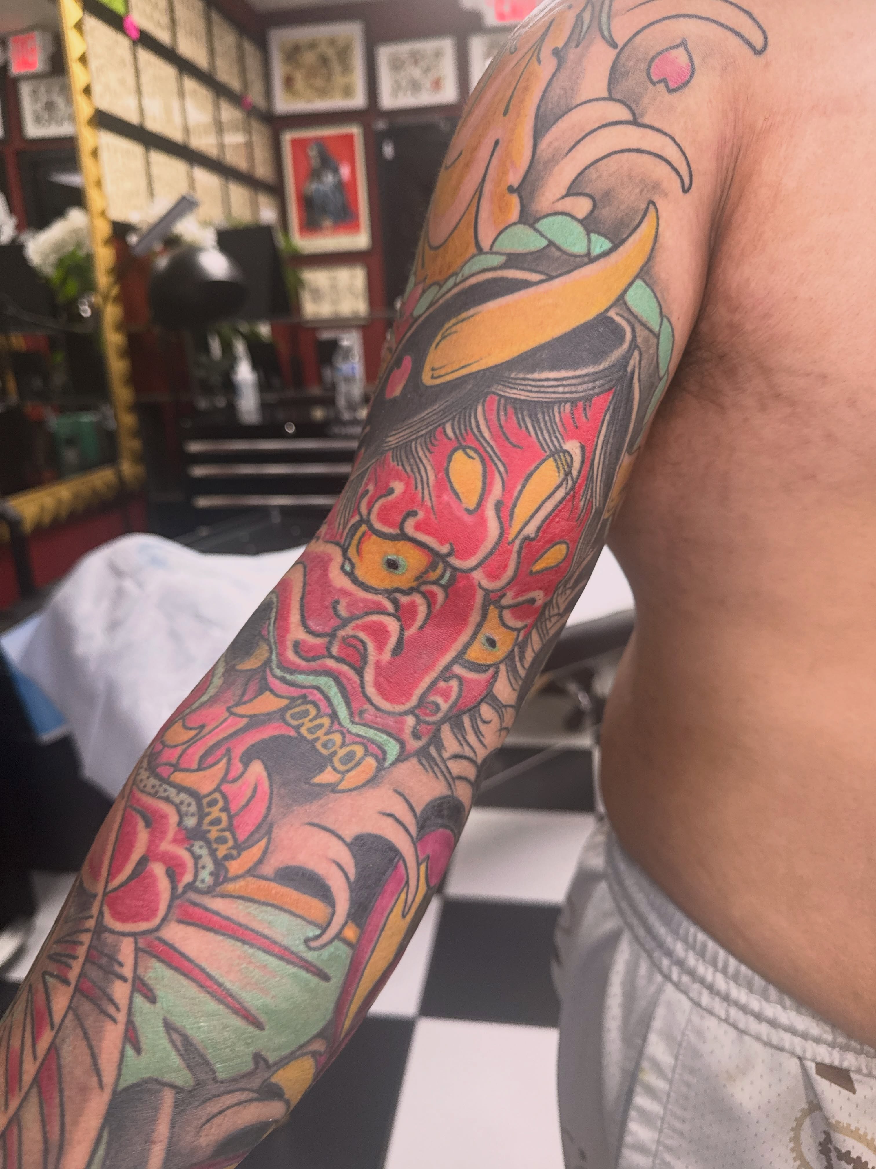 Demon mask American traditional tattoo on the upper arm by Nick Weaver