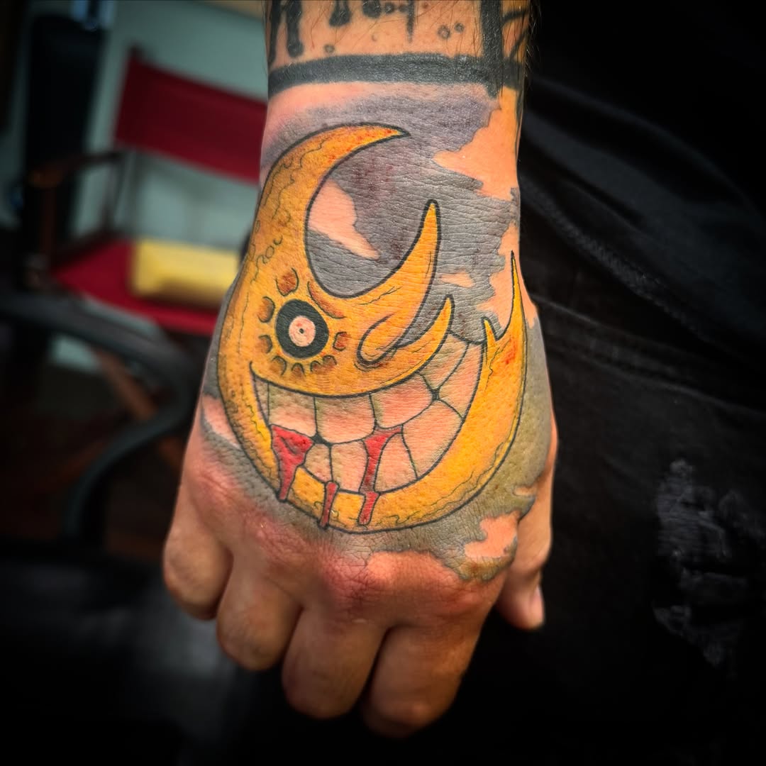 Moon with face American traditional tattoo on the hand by Cory Haberman