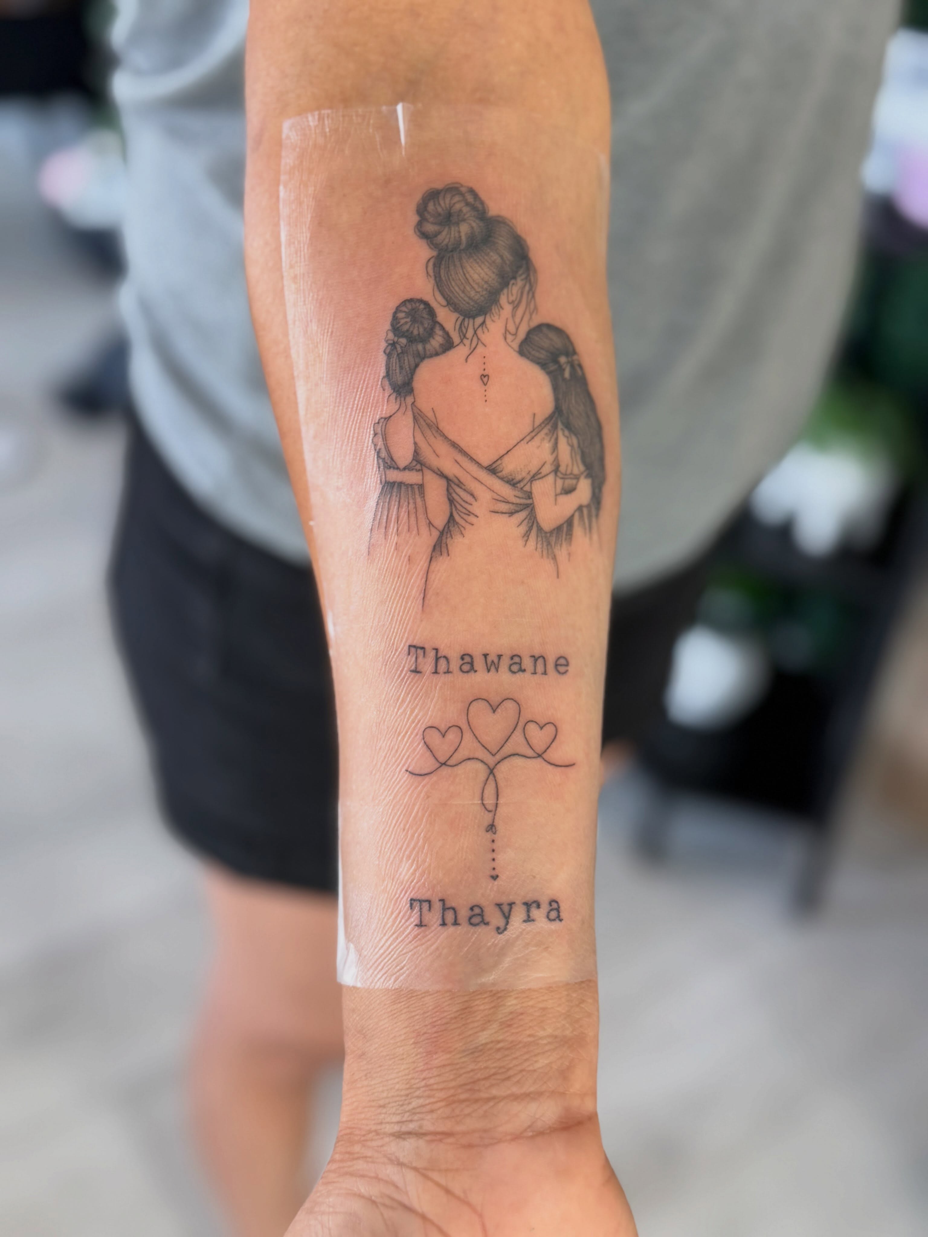 Mother and child black and grey tattoo on the forearm by Silva Wellen