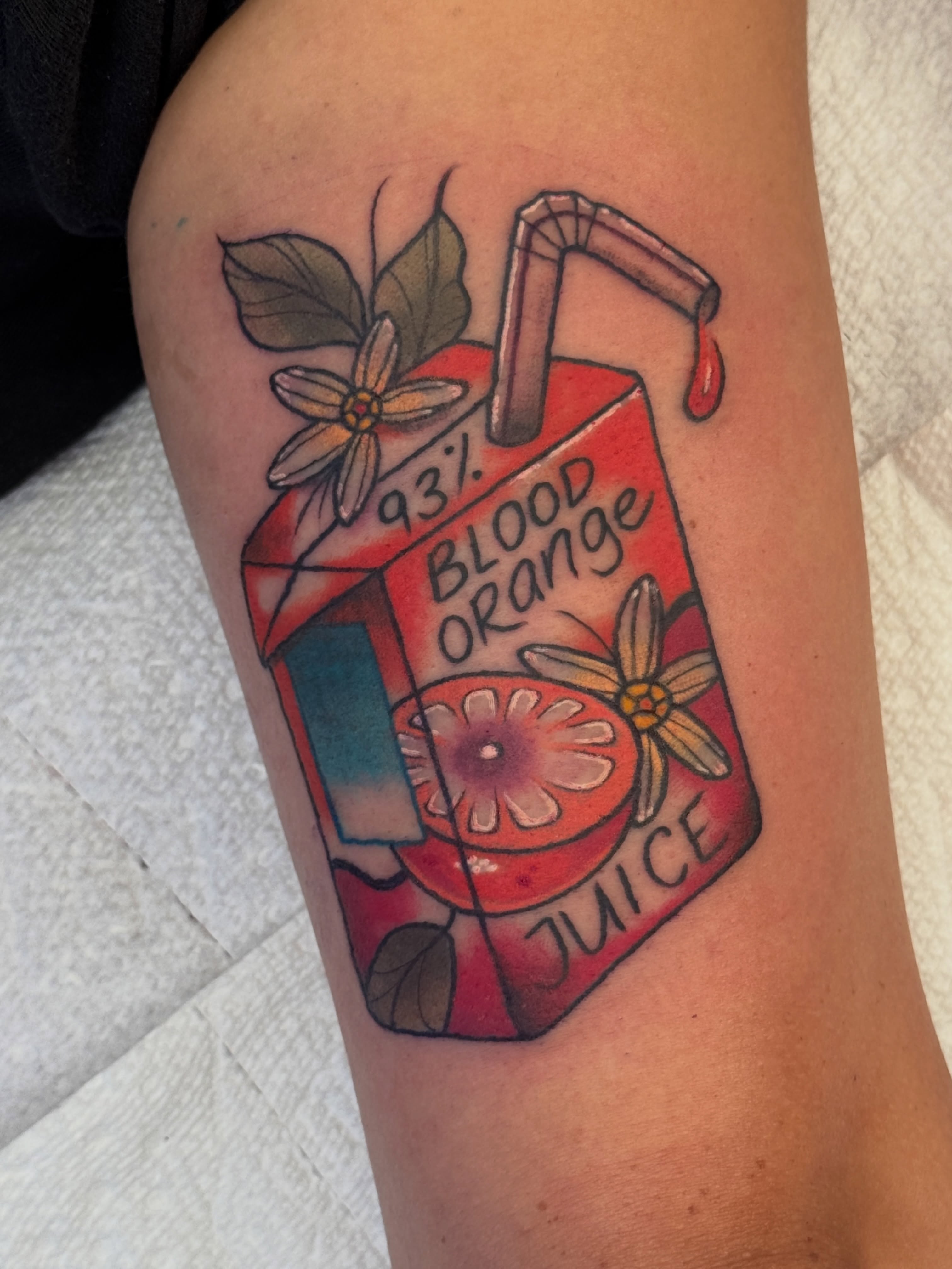 Blood orange juice carton realism tattoo on the forearm by Tattoos by Angel Lee