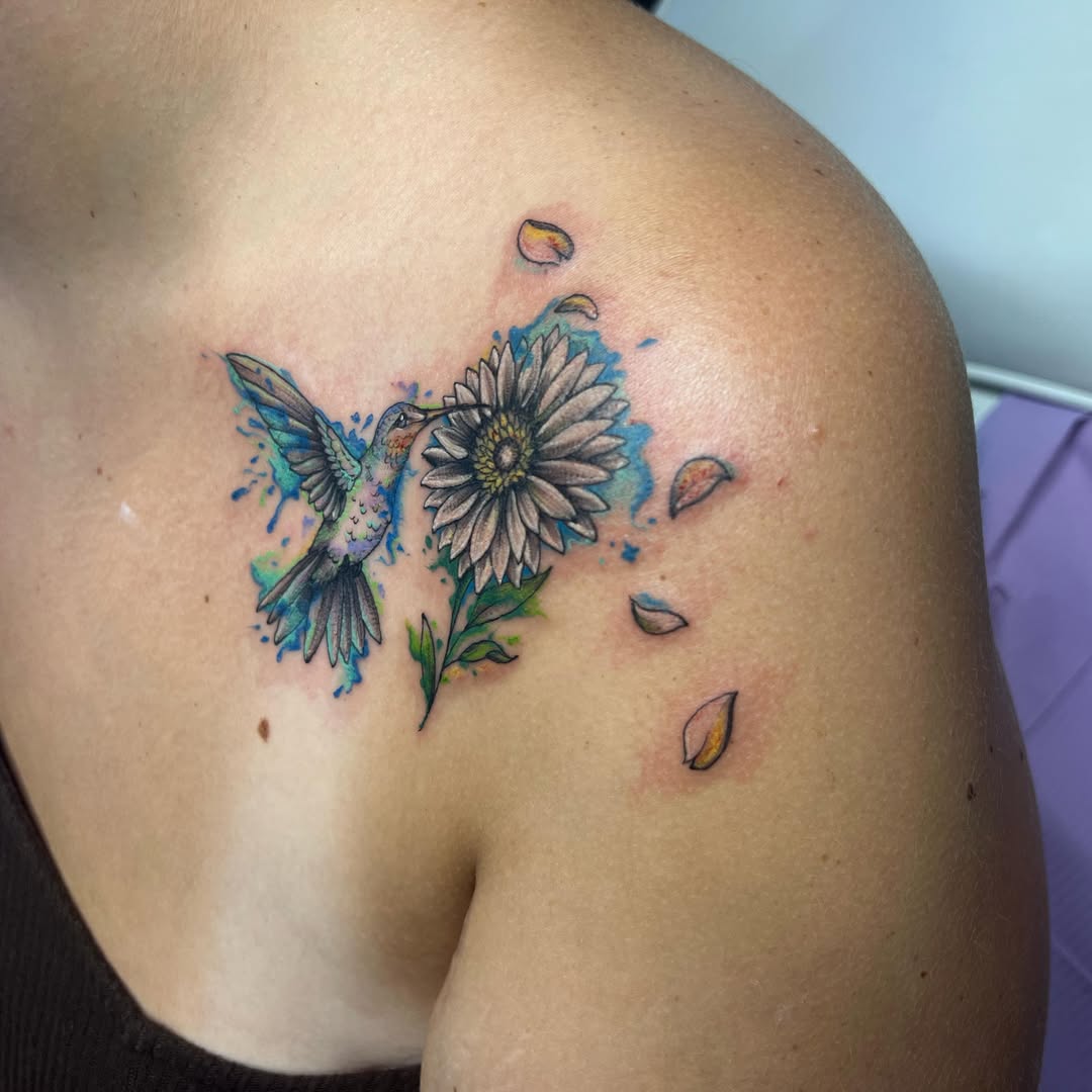 Hummingbird and daisy watercolor tattoo on the shoulder by Rikki
