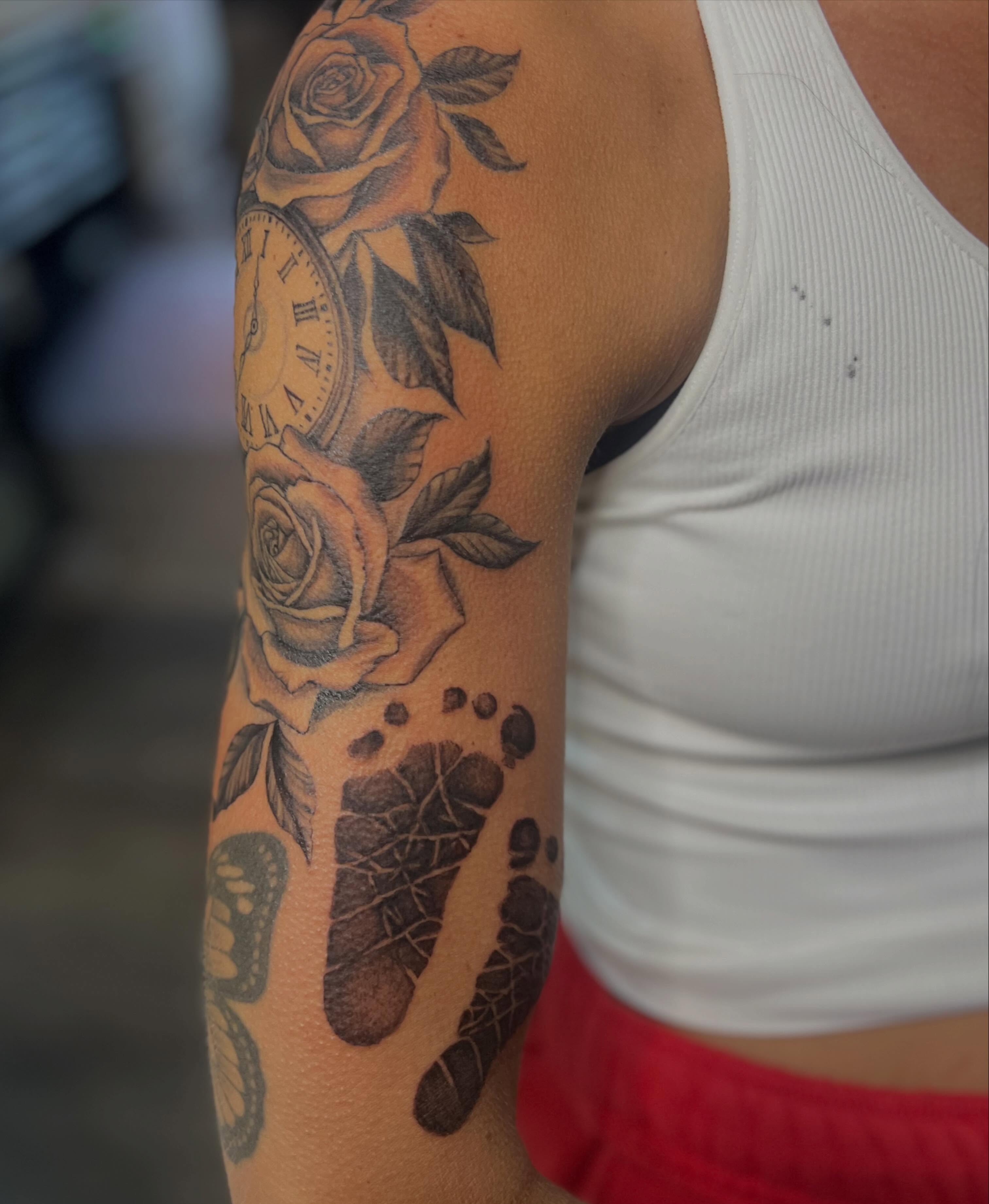 Roses, clock, footprints realism tattoo on the forearm by Rikki