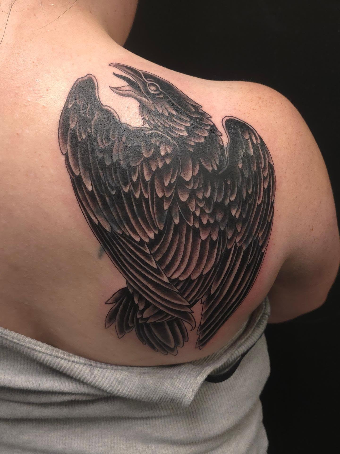 Crow black and grey tattoo on the shoulder by Trinity