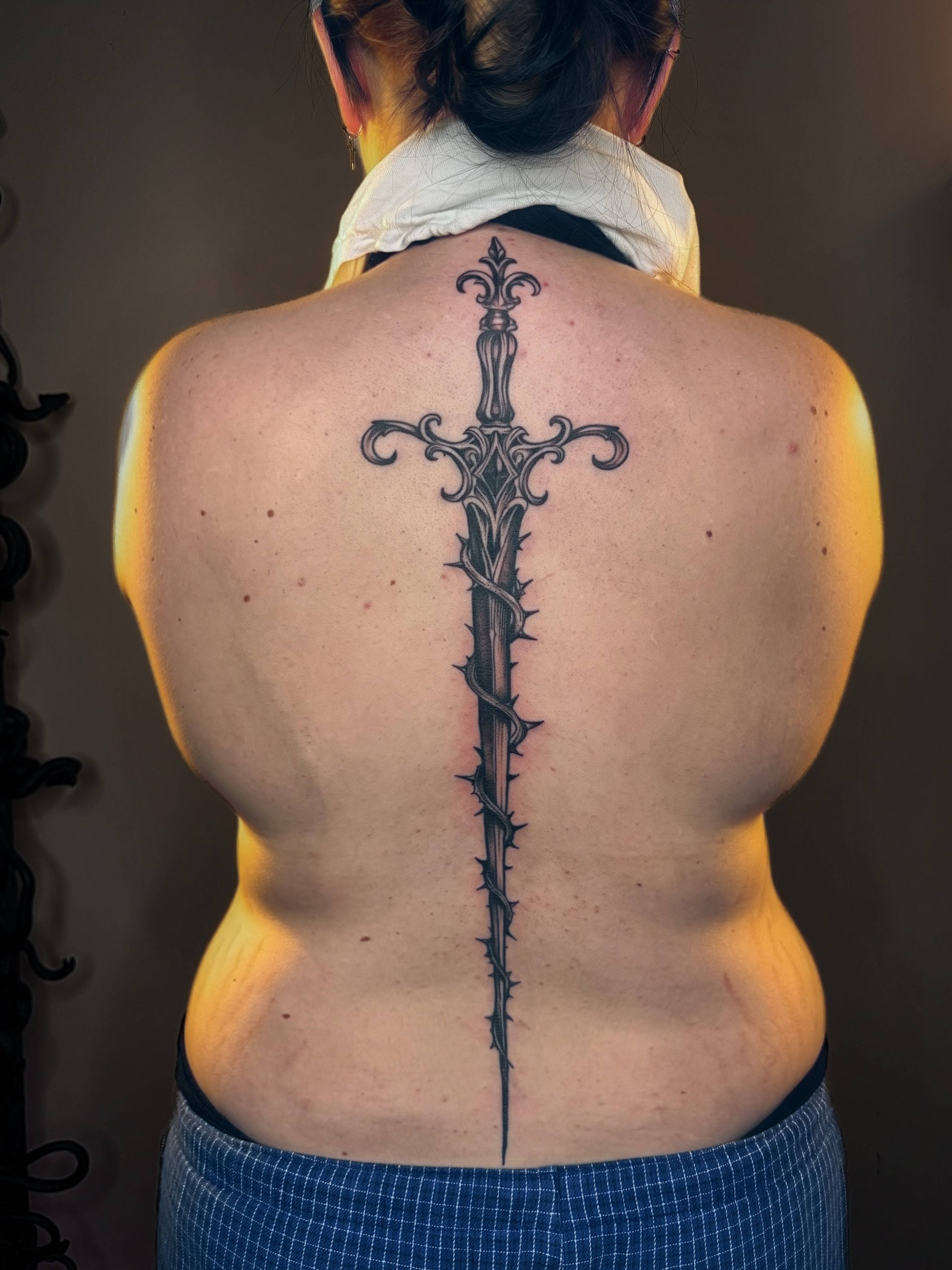 Sword ornamental tattoo on the back by Imani