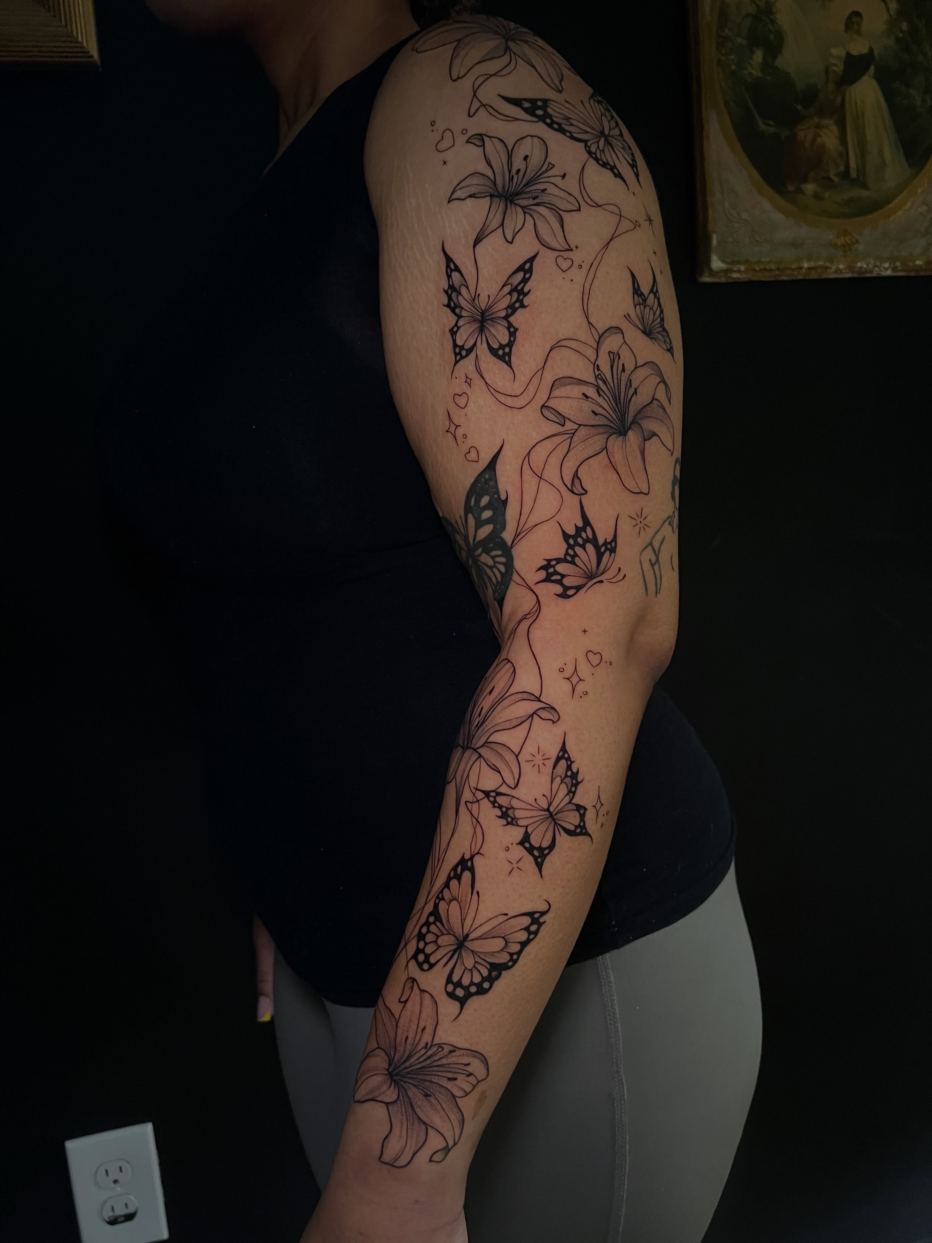 Butterflies and lilies black and grey tattoo on the forearm by Baung Ben