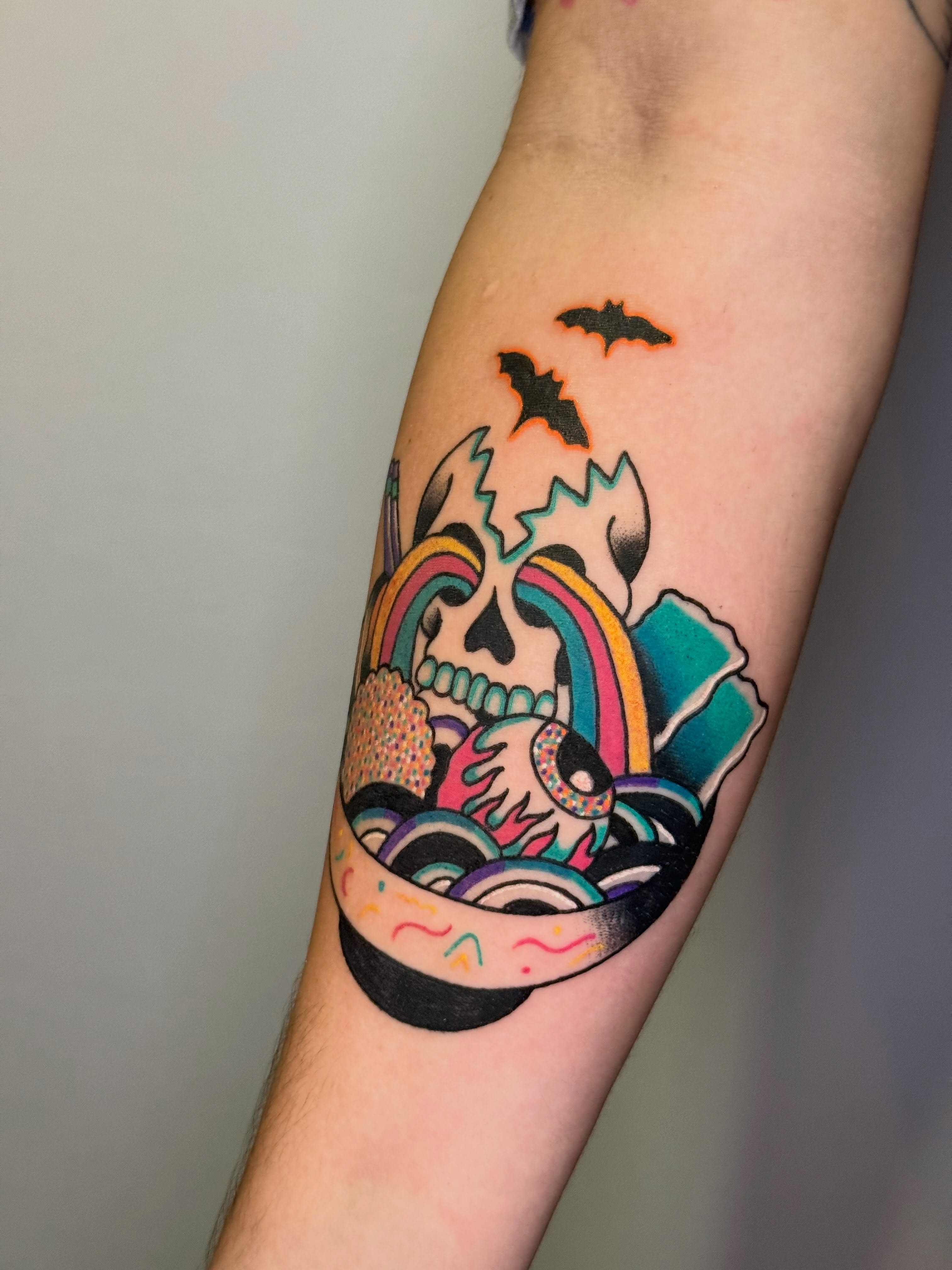 Skull and rainbow new school tattoo on the forearm by Diana Muresan
