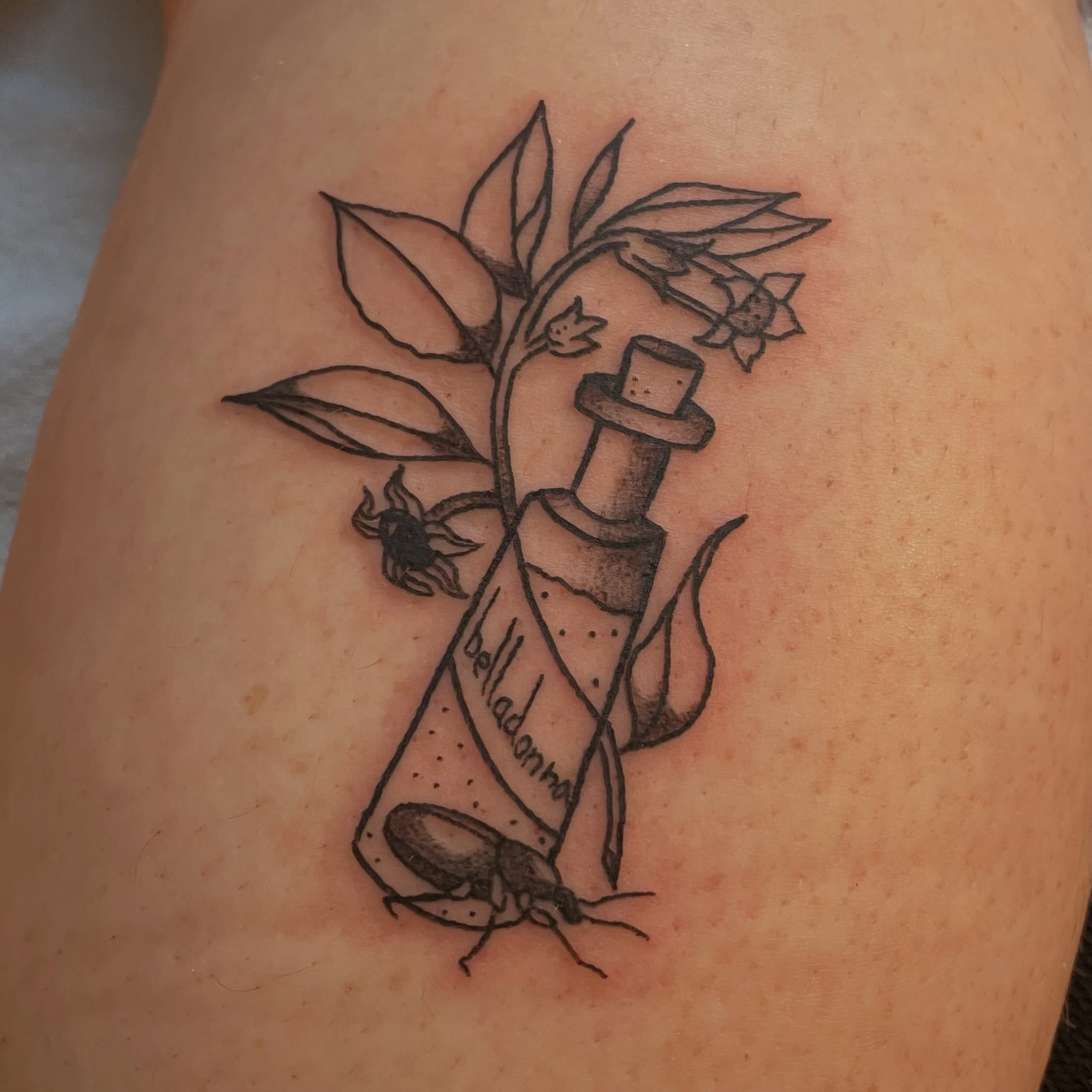 Belladonna bottle black and grey tattoo on the thigh by Avalon Sable