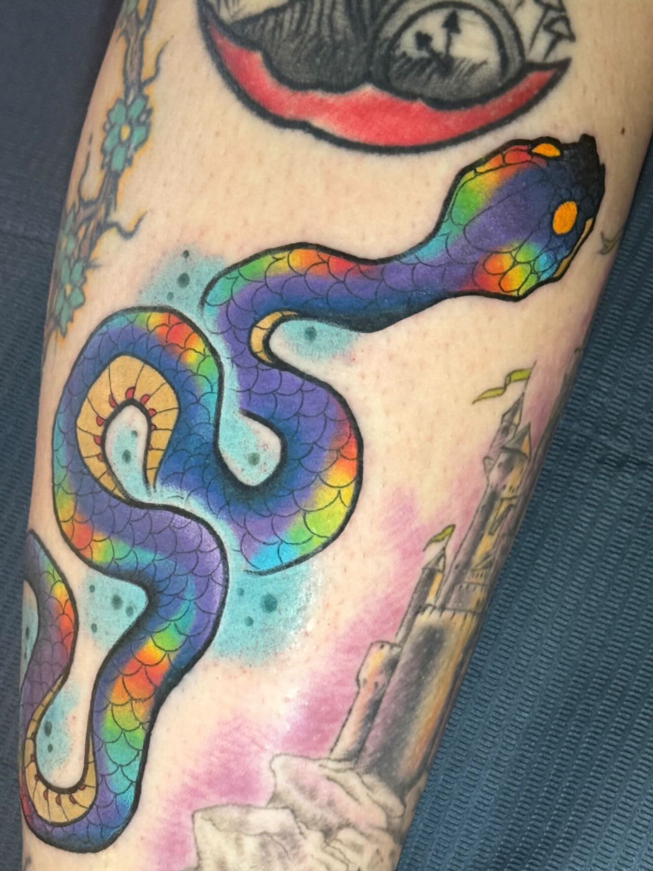 Rainbow snake new school tattoo on the forearm by Geoff “Split” DiVittorio